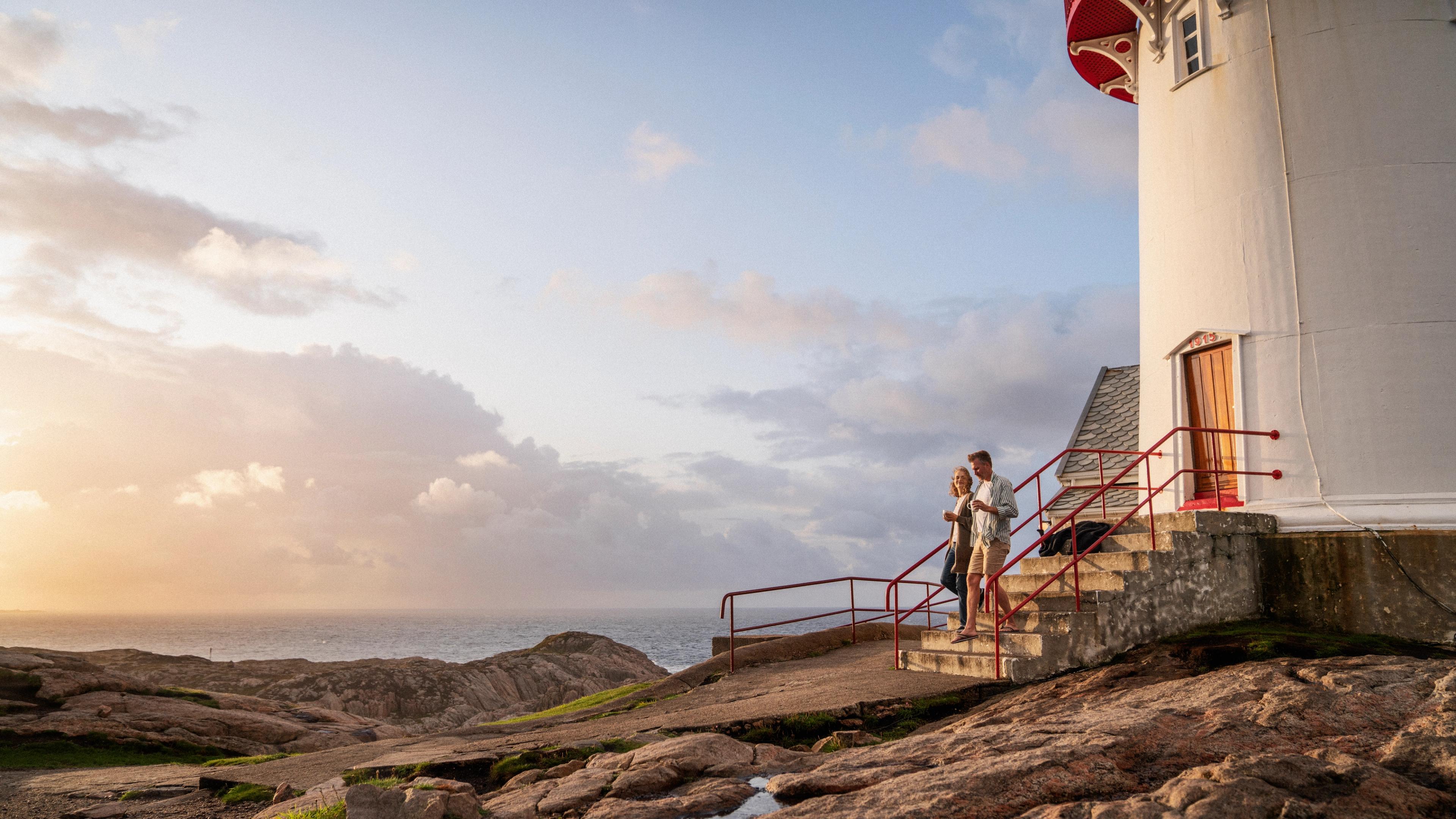 A couple walking beside a lighthouse in Southern Norway.