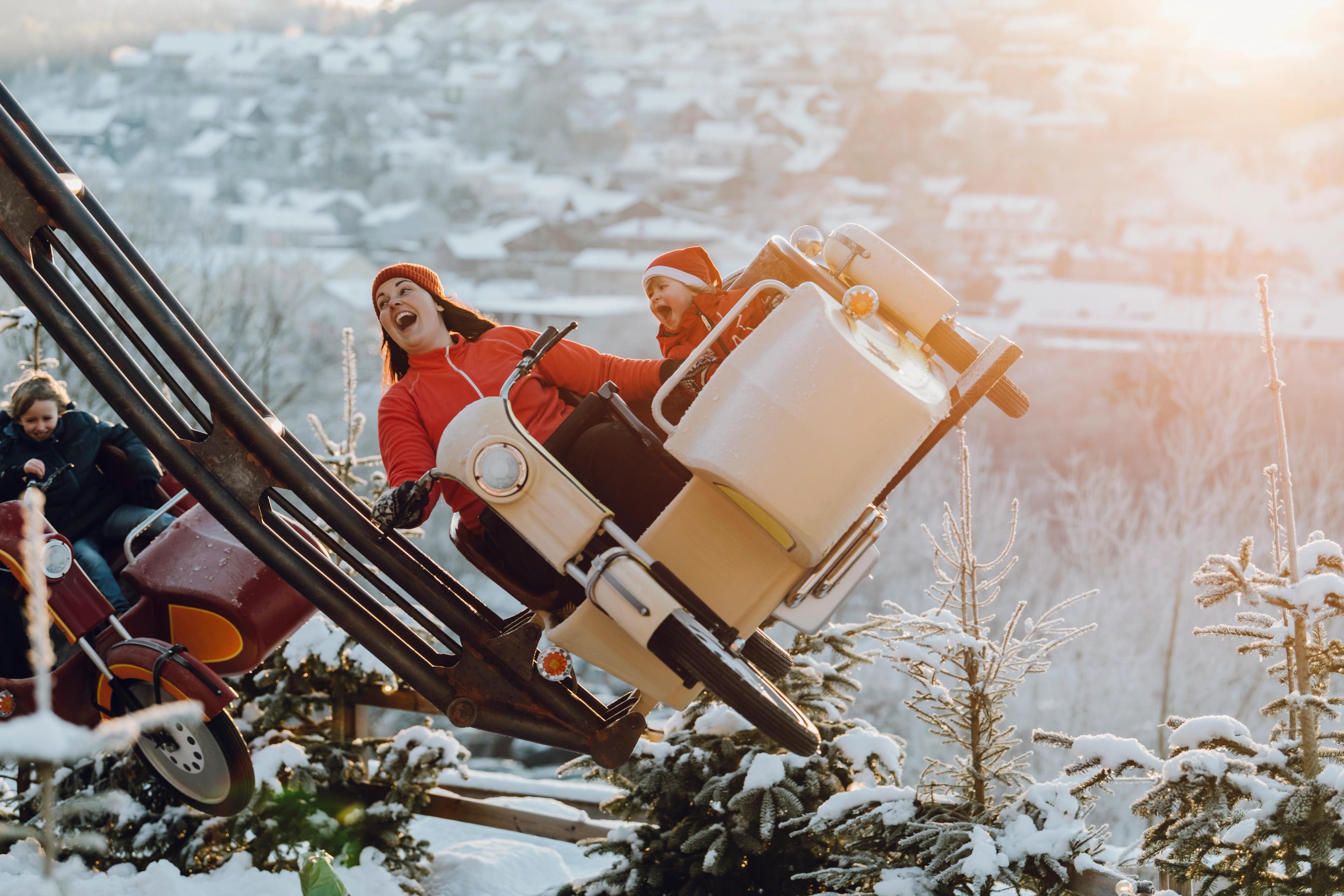 Mor og barn kjører karusell nissedrakter i Kongeparken utenfor Stavanger på Vestlandet