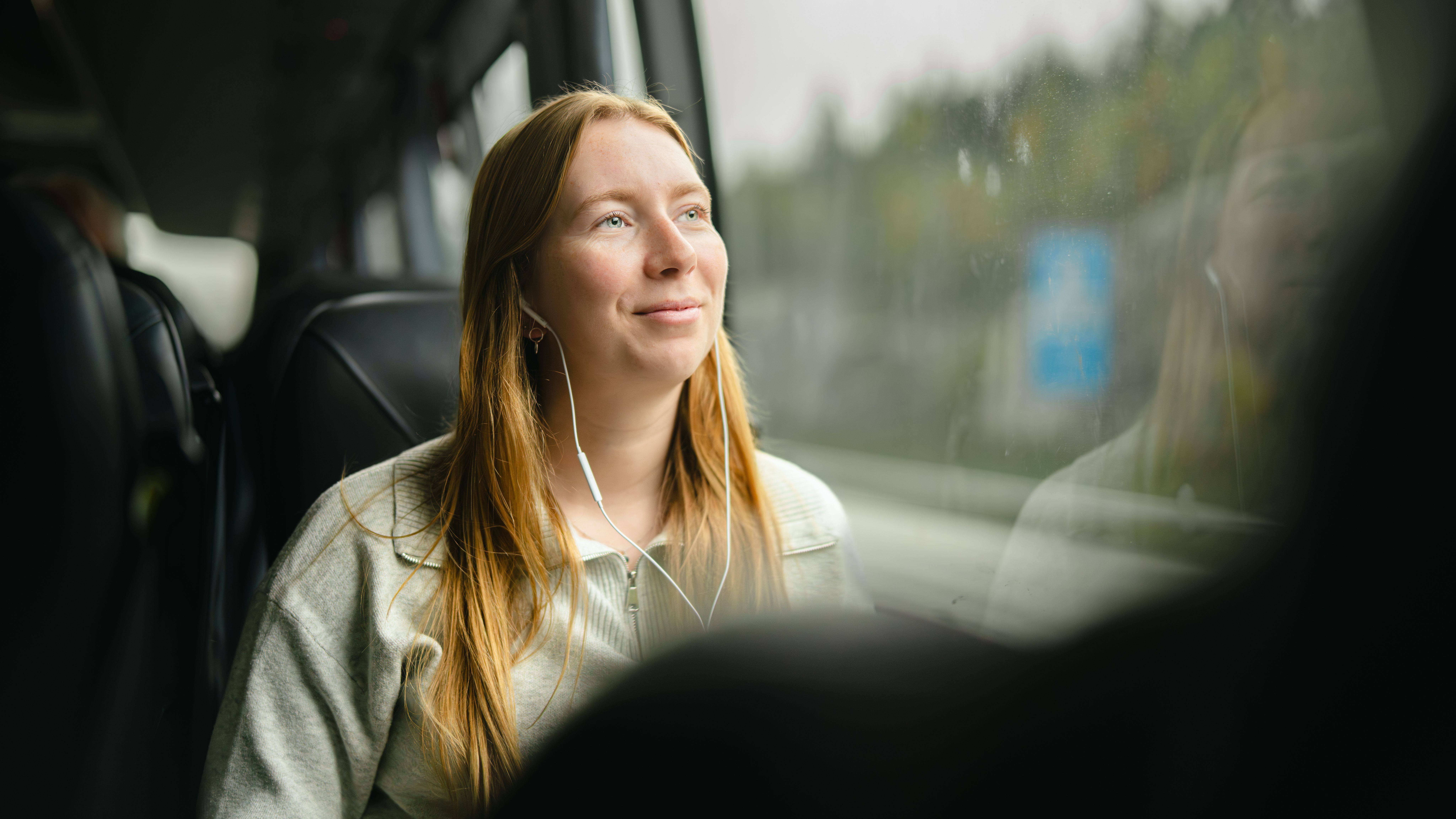 A woman on a bus looking out the window.