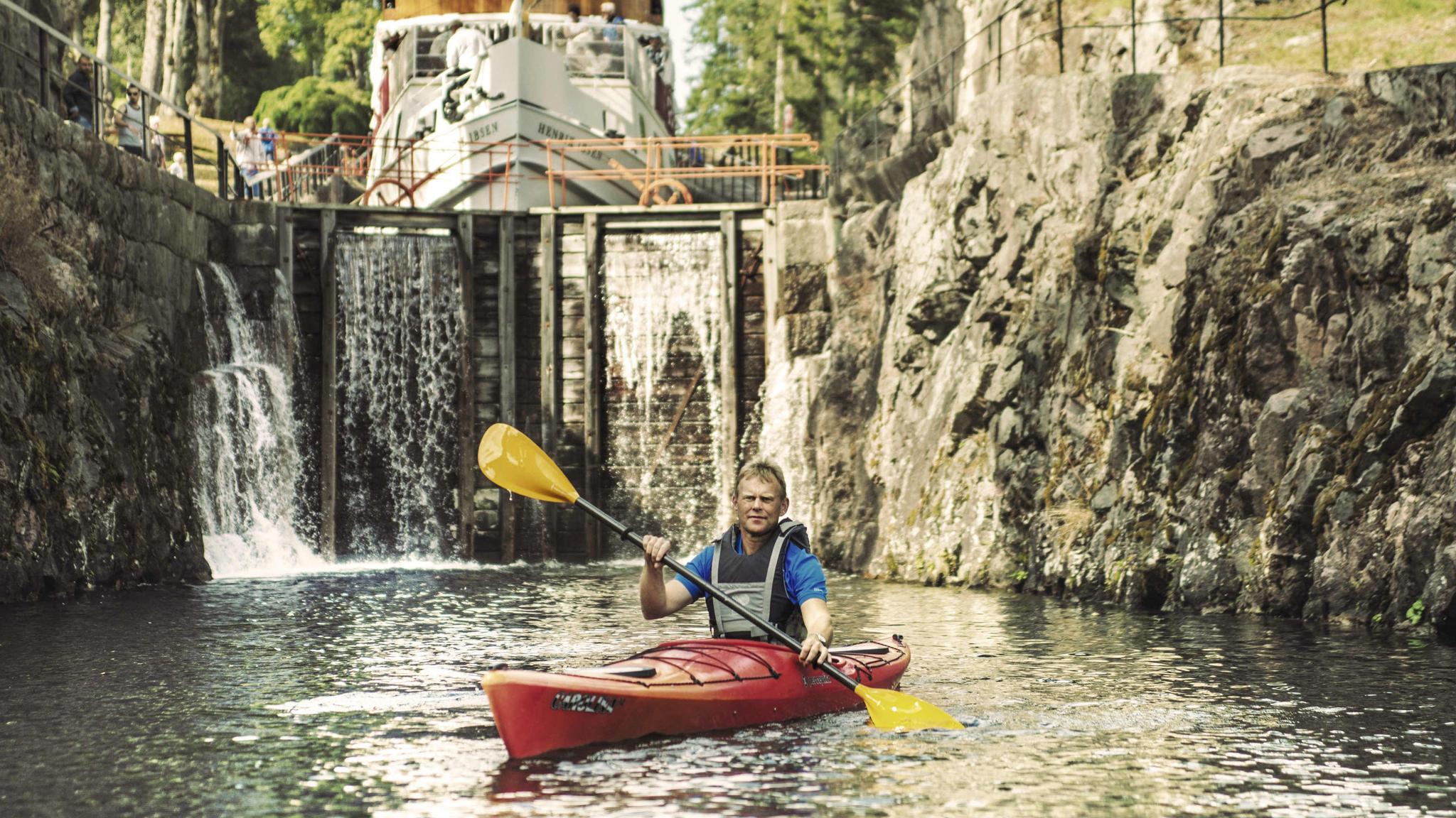 En person paddlar kajak längs Telemarkskanalen, Østlandet (östra Norge)
