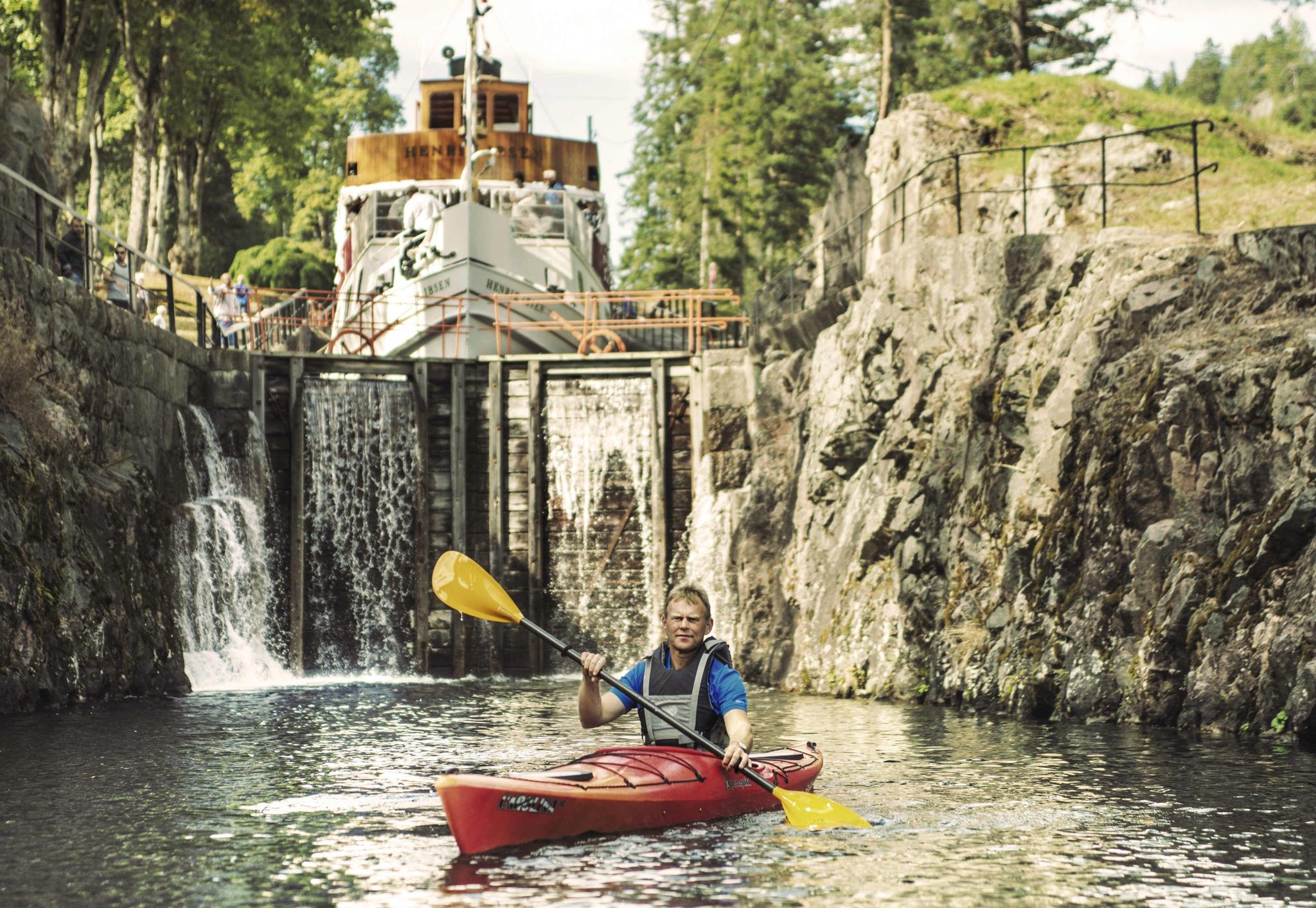 A man paddling in a kayak on the Telemark canal in Eastern Norway