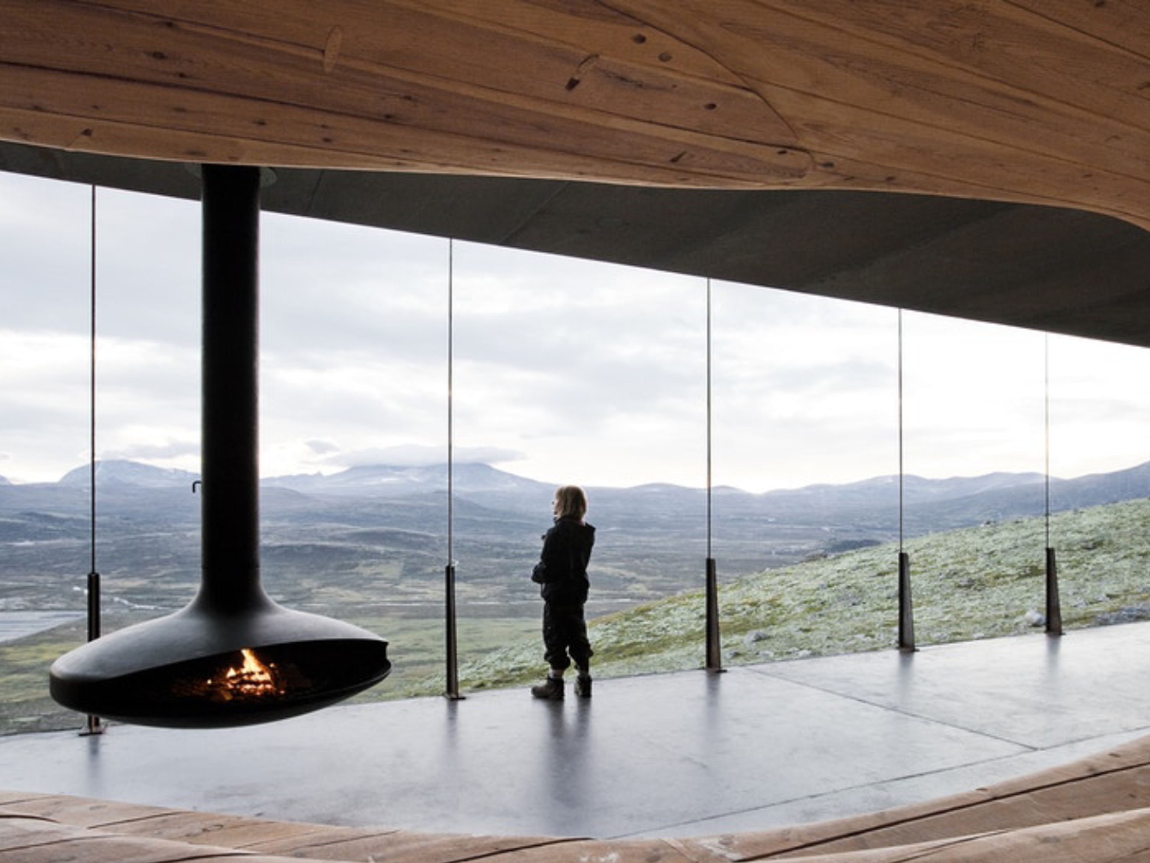 A person looking at the view from inside the Viewpoint Snøhetta in Hjerkinn.