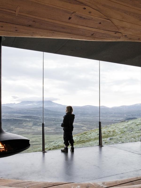 A person looking at the view from inside the Viewpoint Snøhetta in Hjerkinn.