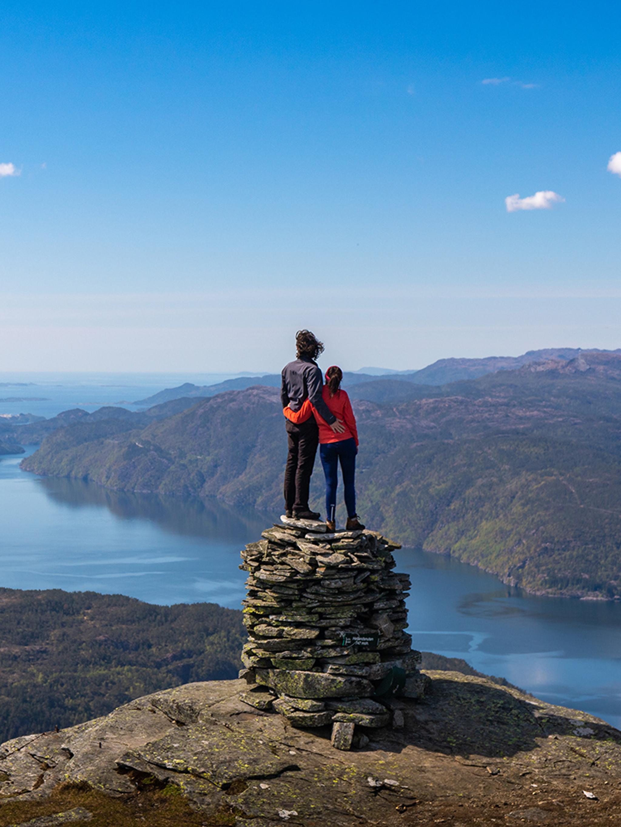 A couple on a mountain top with fjord view in Suldal in Ryfylke, Fjord Norway