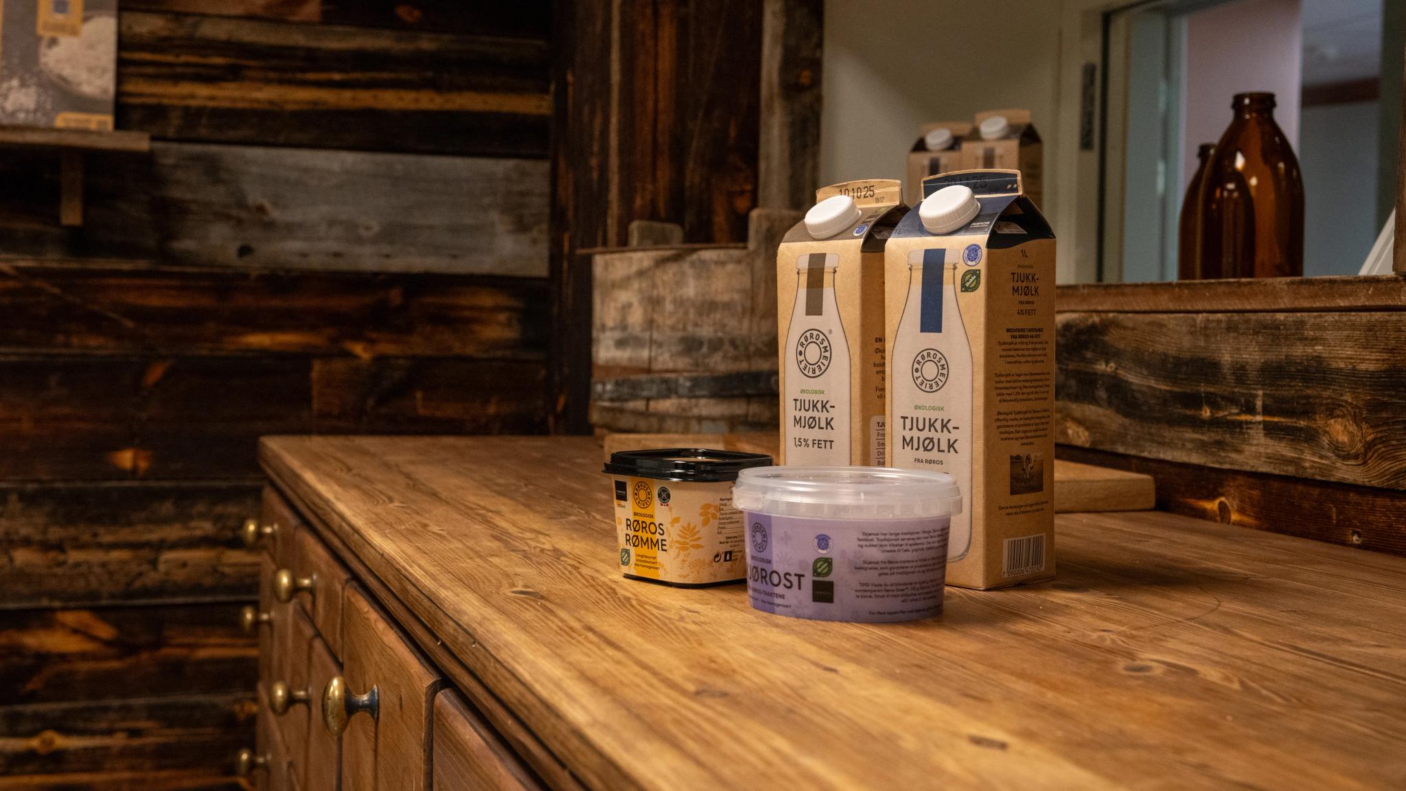 Different products from Røros dairy on a wooden counter top.