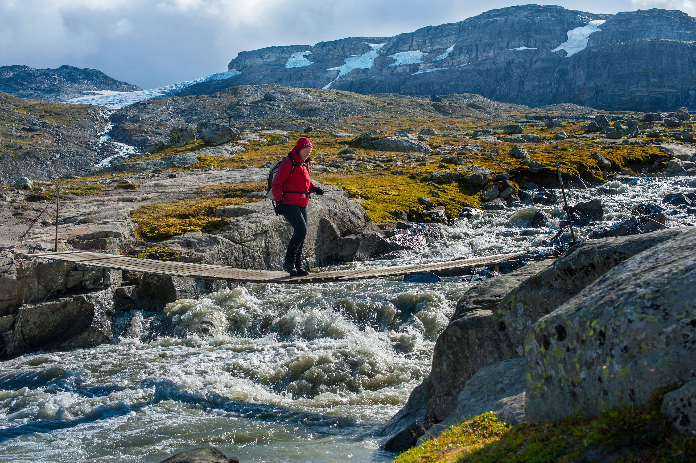 Female hiker crossing a bridge in Hardangervidda