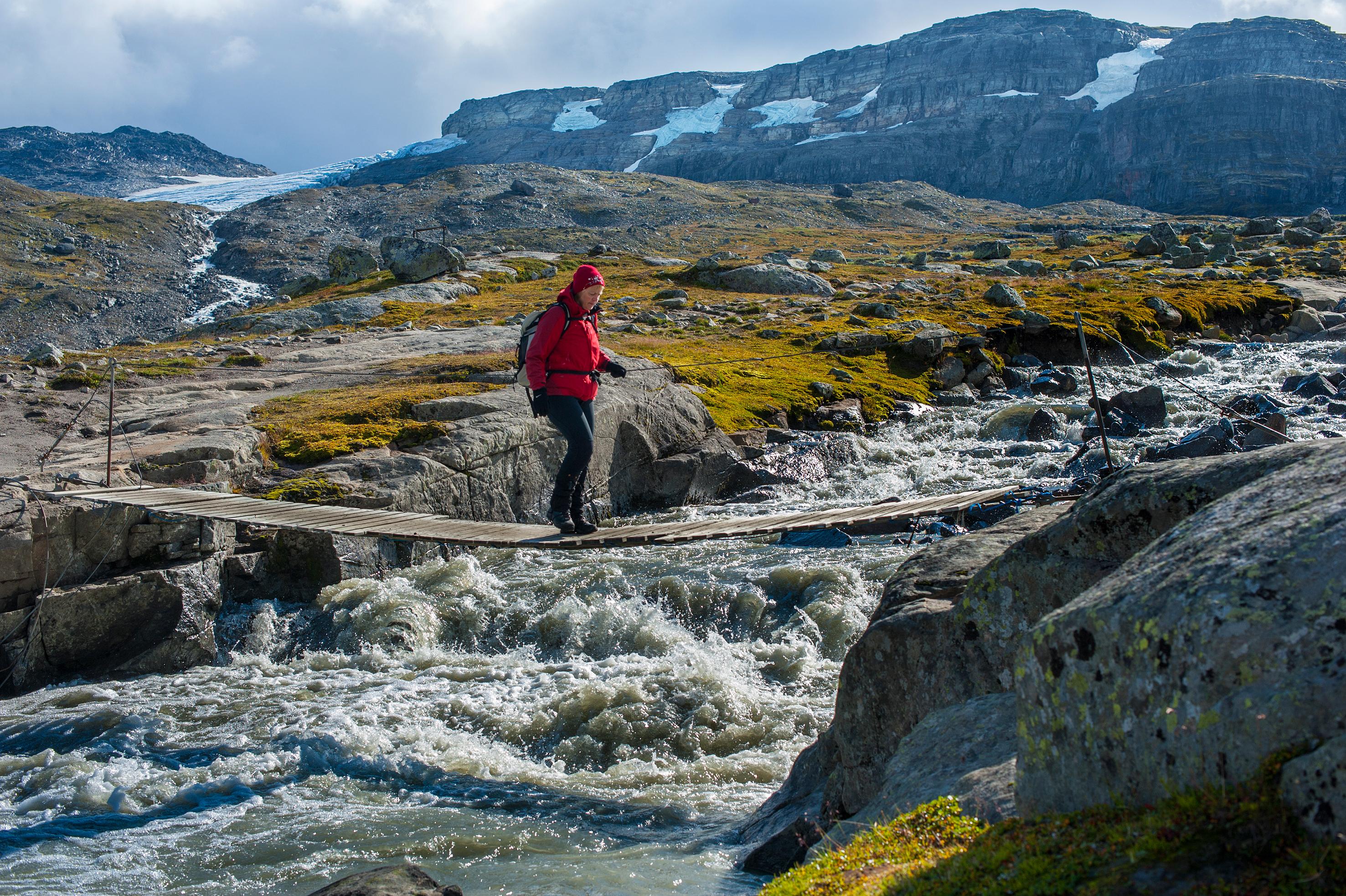Female hiker crossing a bridge in Hardangervidda