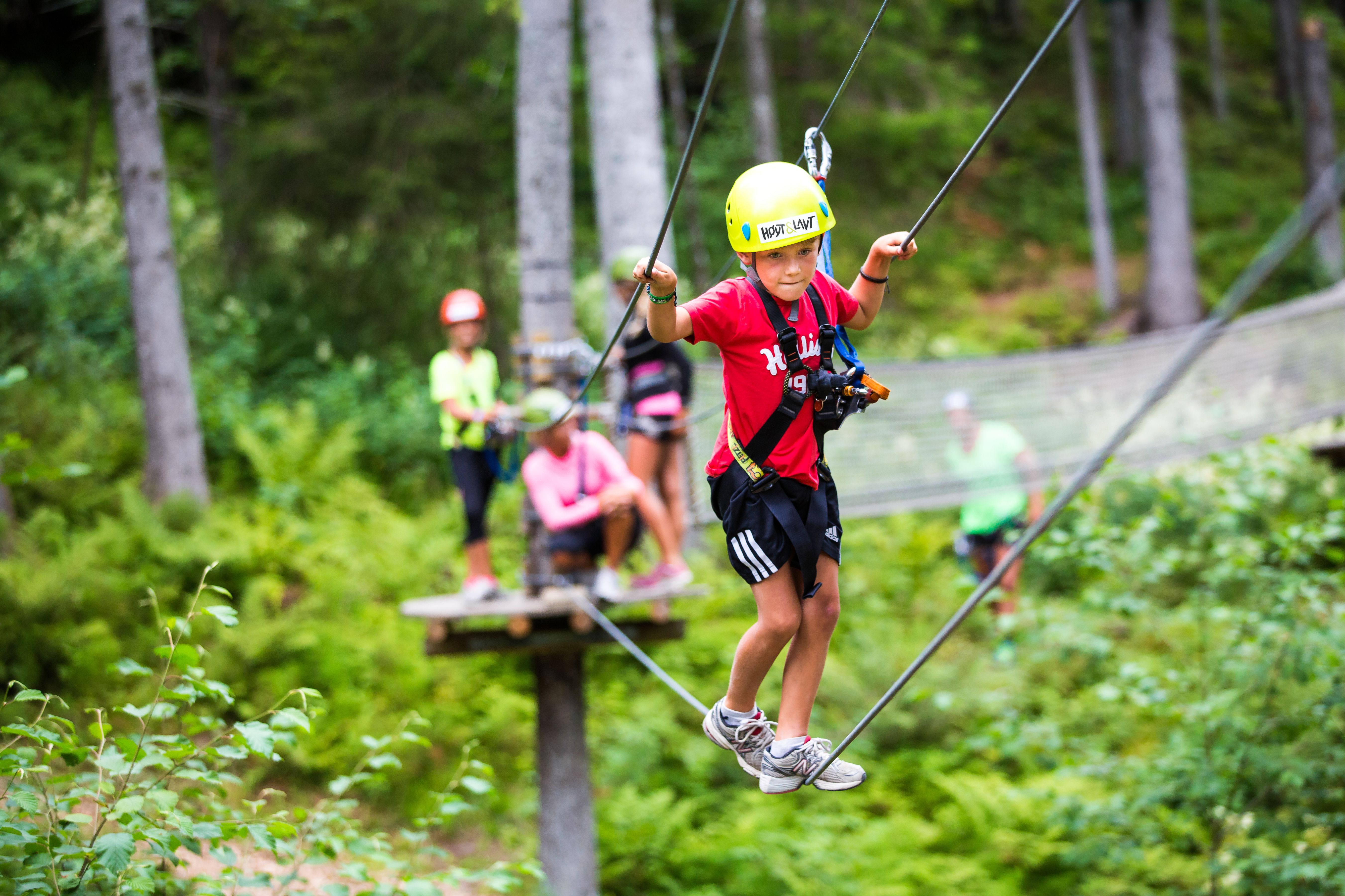 A young boy balancing on a rope in the climbing park Høyt & Lavt Vestfold in Eastern Norway