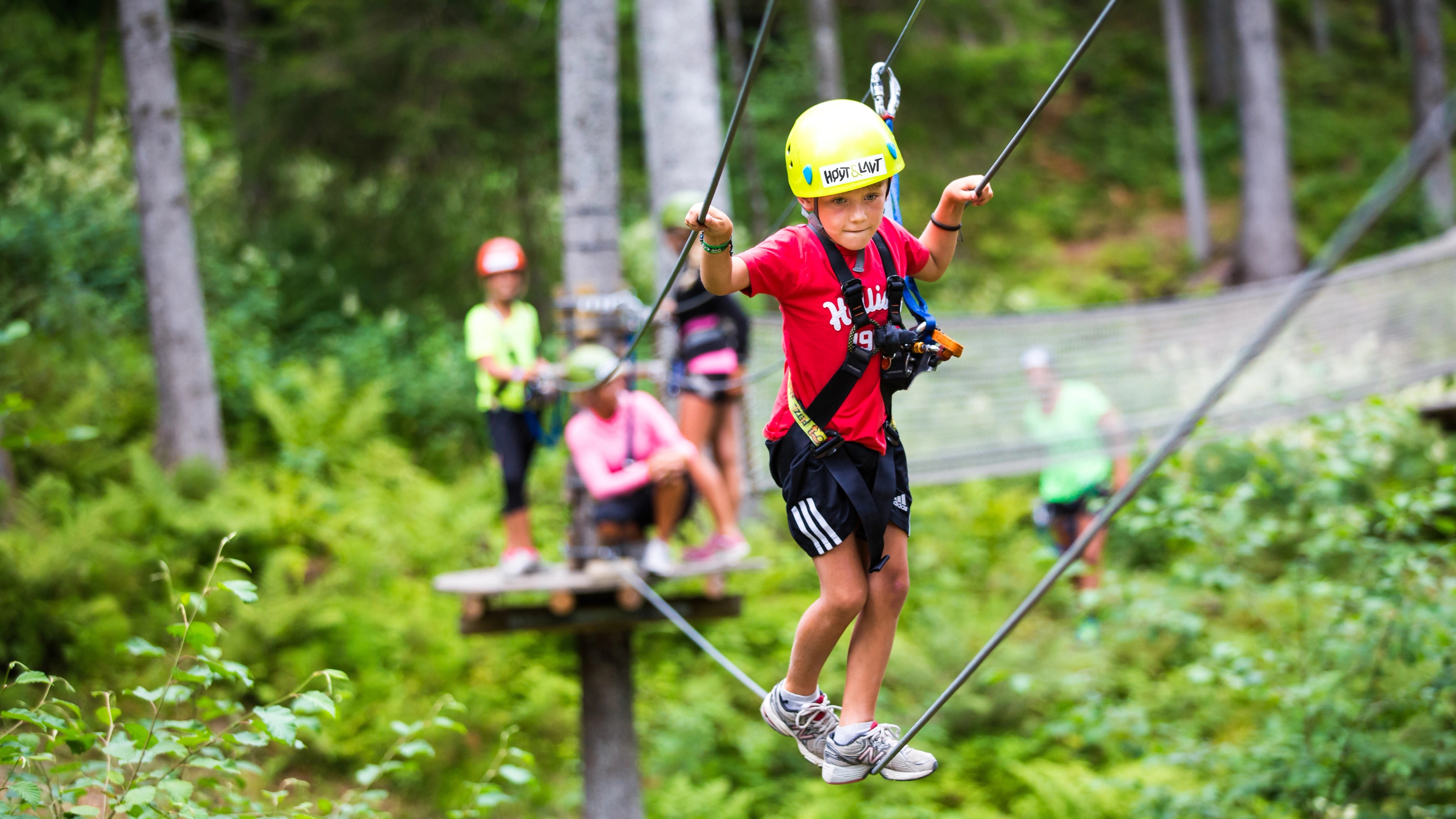 A young boy balancing on a rope in the climbing park Høyt & Lavt Vestfold in Eastern Norway