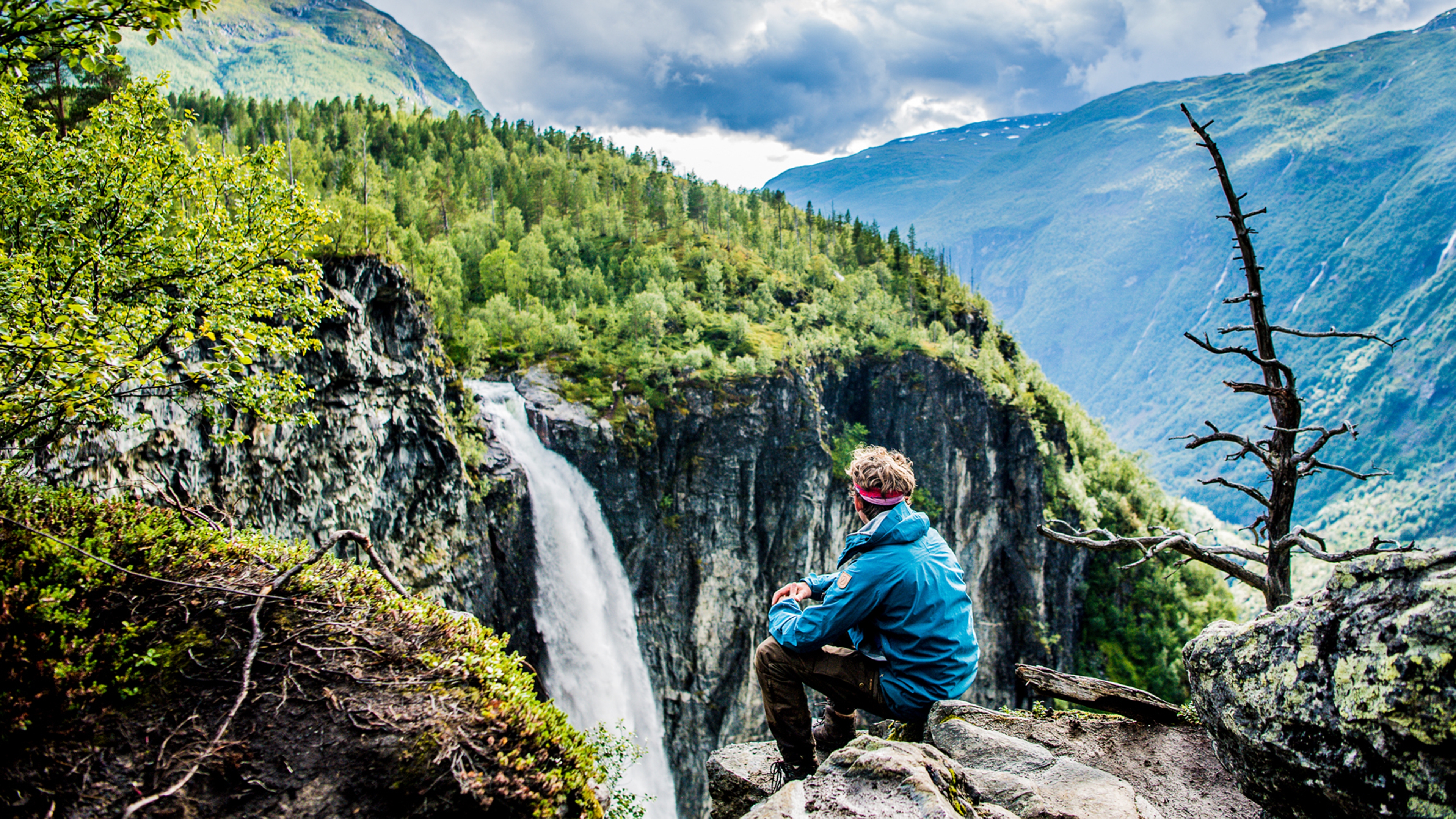 A man enjoying the view of the Vettisfossen waterfall in Utladalen in the Jotunheimen mountains, Norway