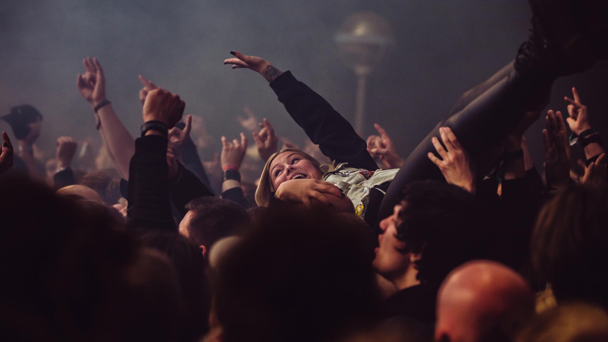 A woman is crowd surfing at Karmøygeddon Metal Festival in Haugesund in Fjord Norway