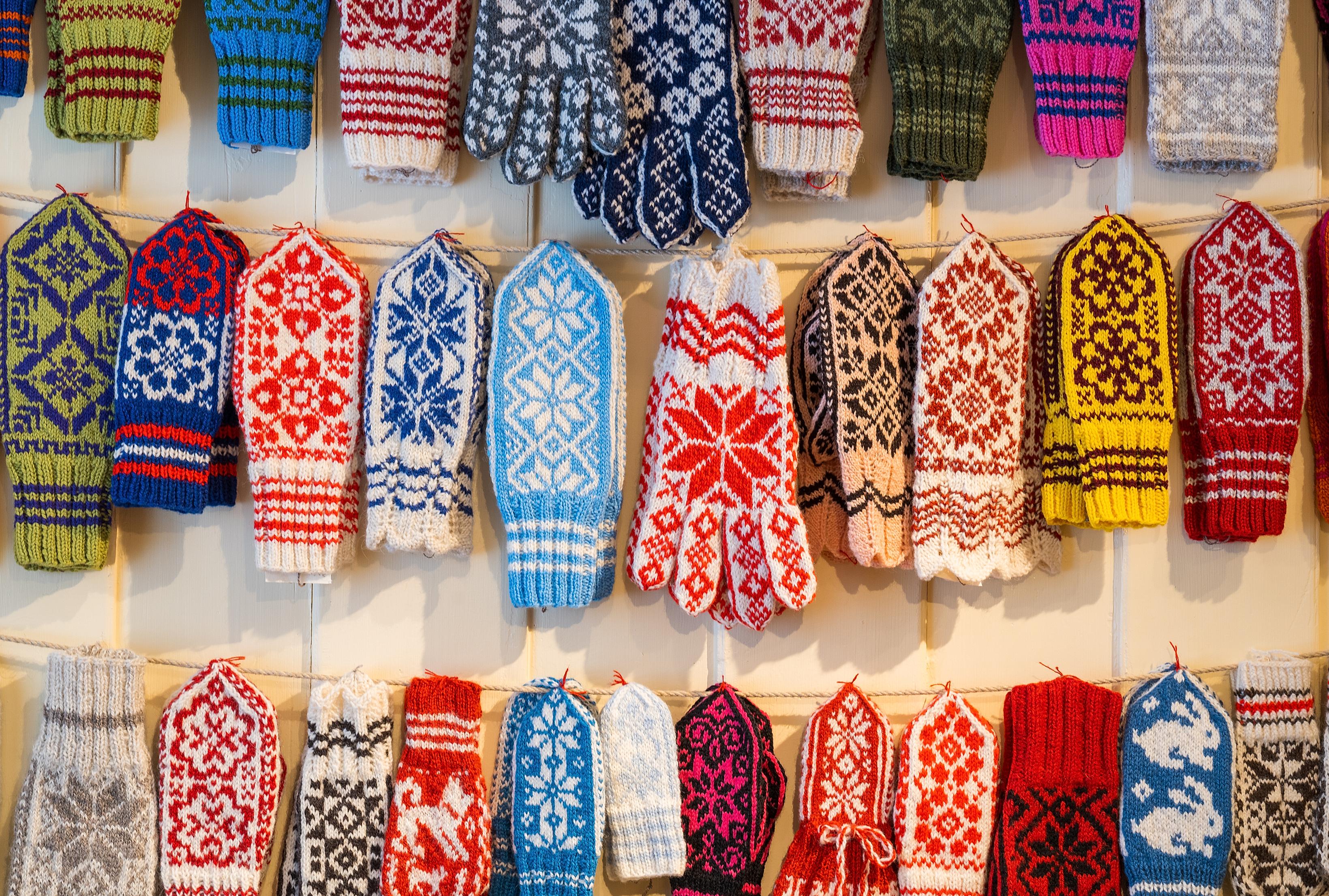 Selbu mittens in different colors hanging on the wall at Selbu Husflidscentral.