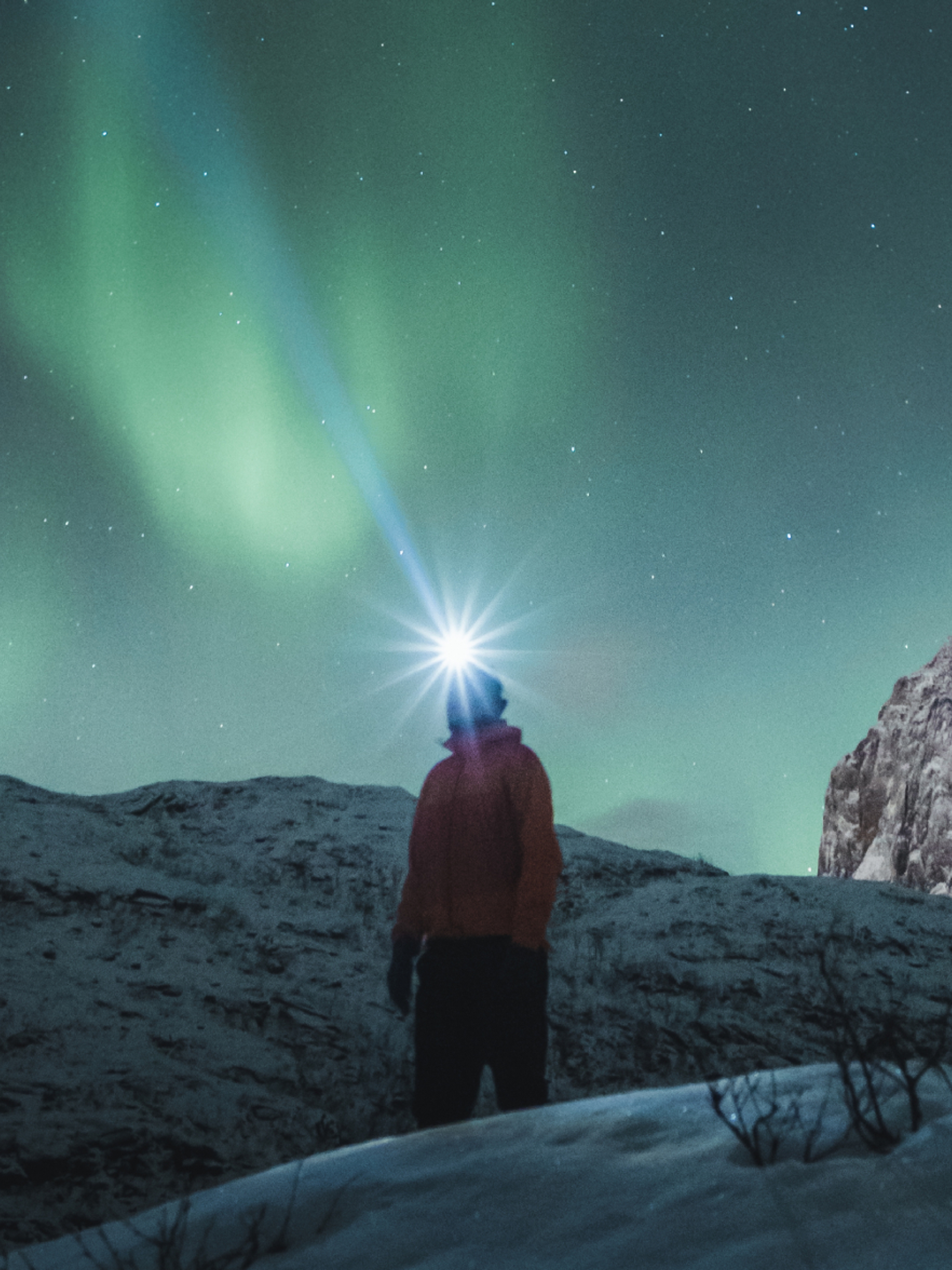 Man watching the northern lights over Mefjordsletta, Senja