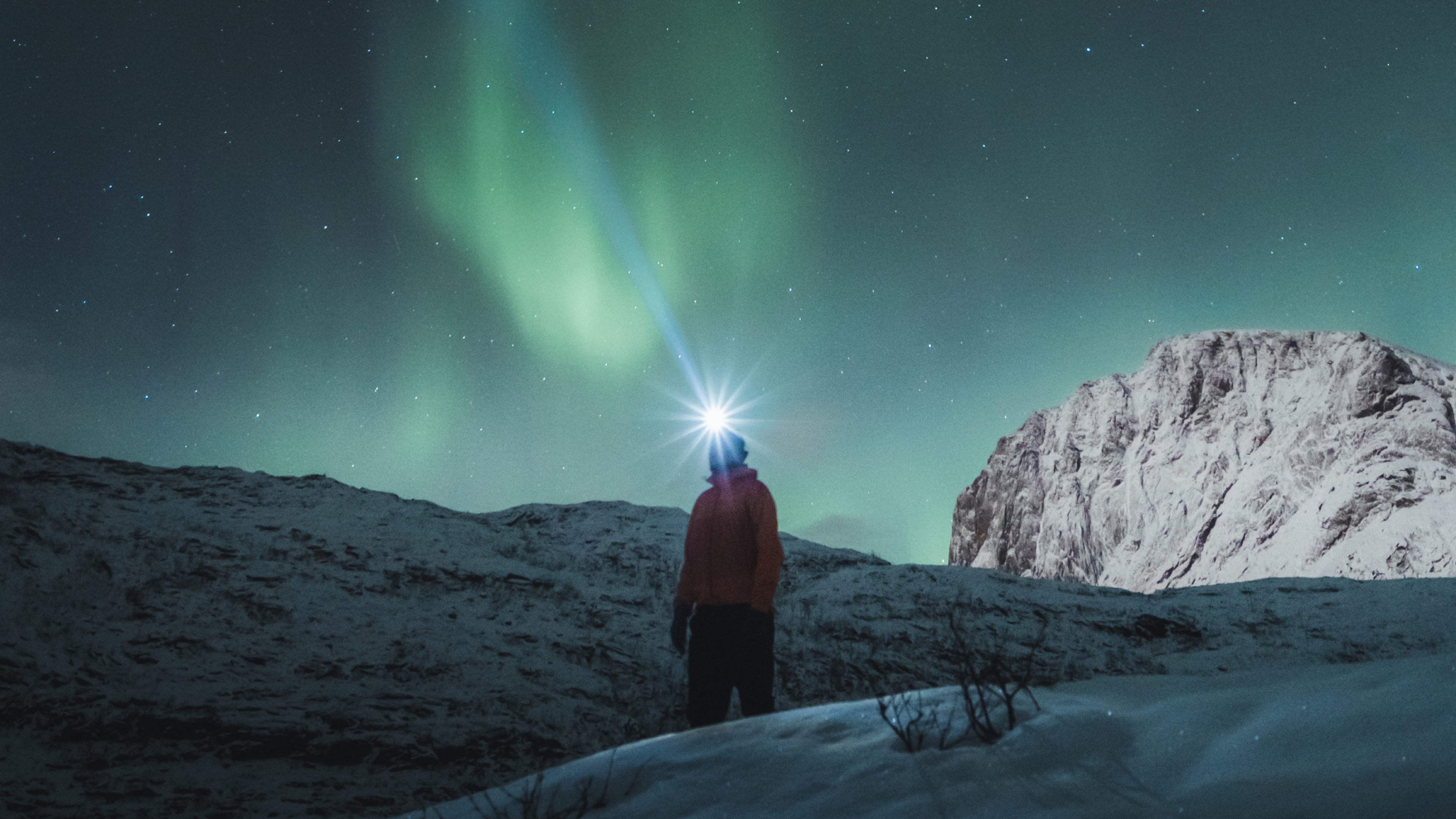 Man watching the northern lights over Mefjordsletta, Senja