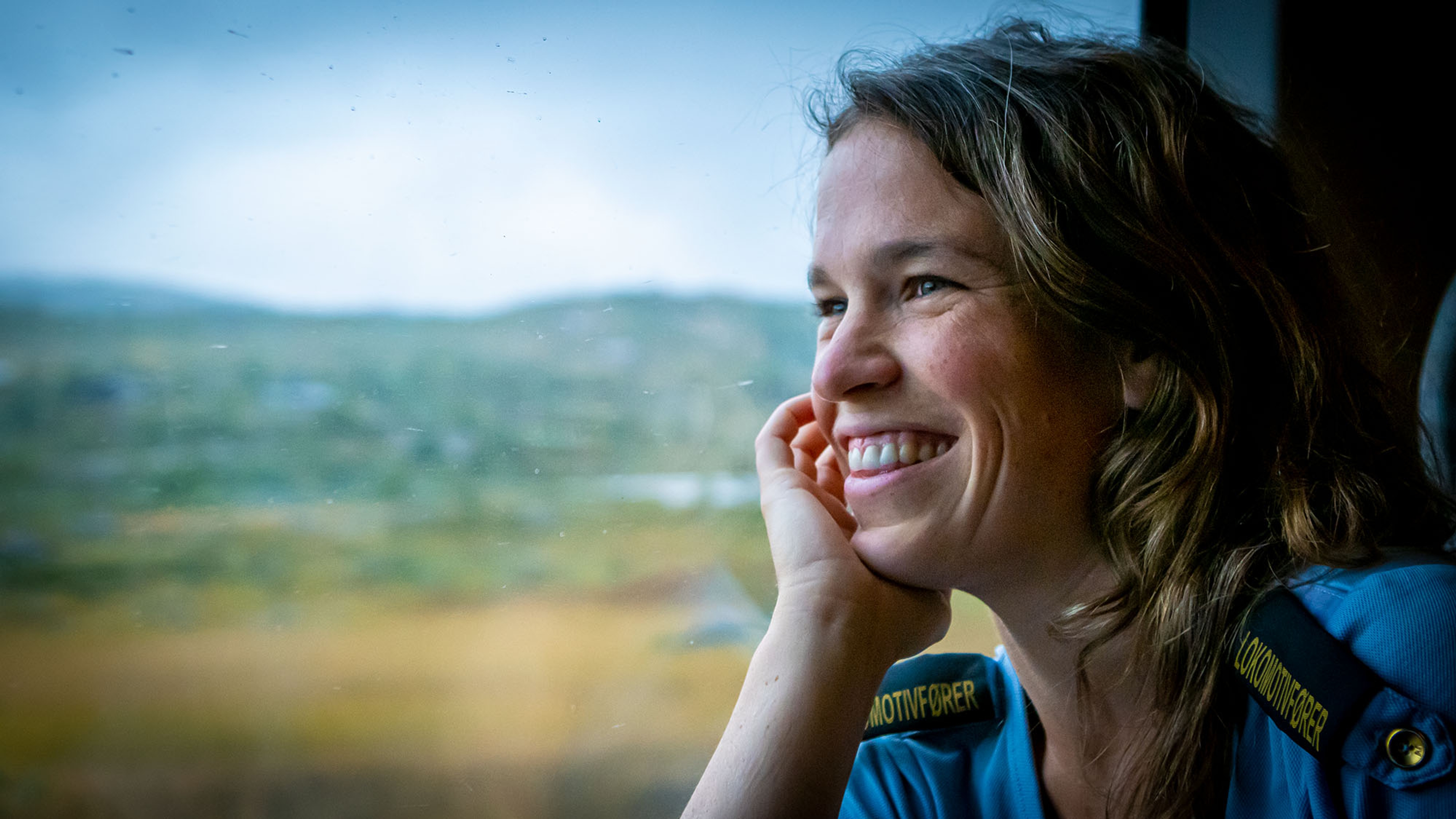 A train driver is looking through the window at the Bergen Railway train