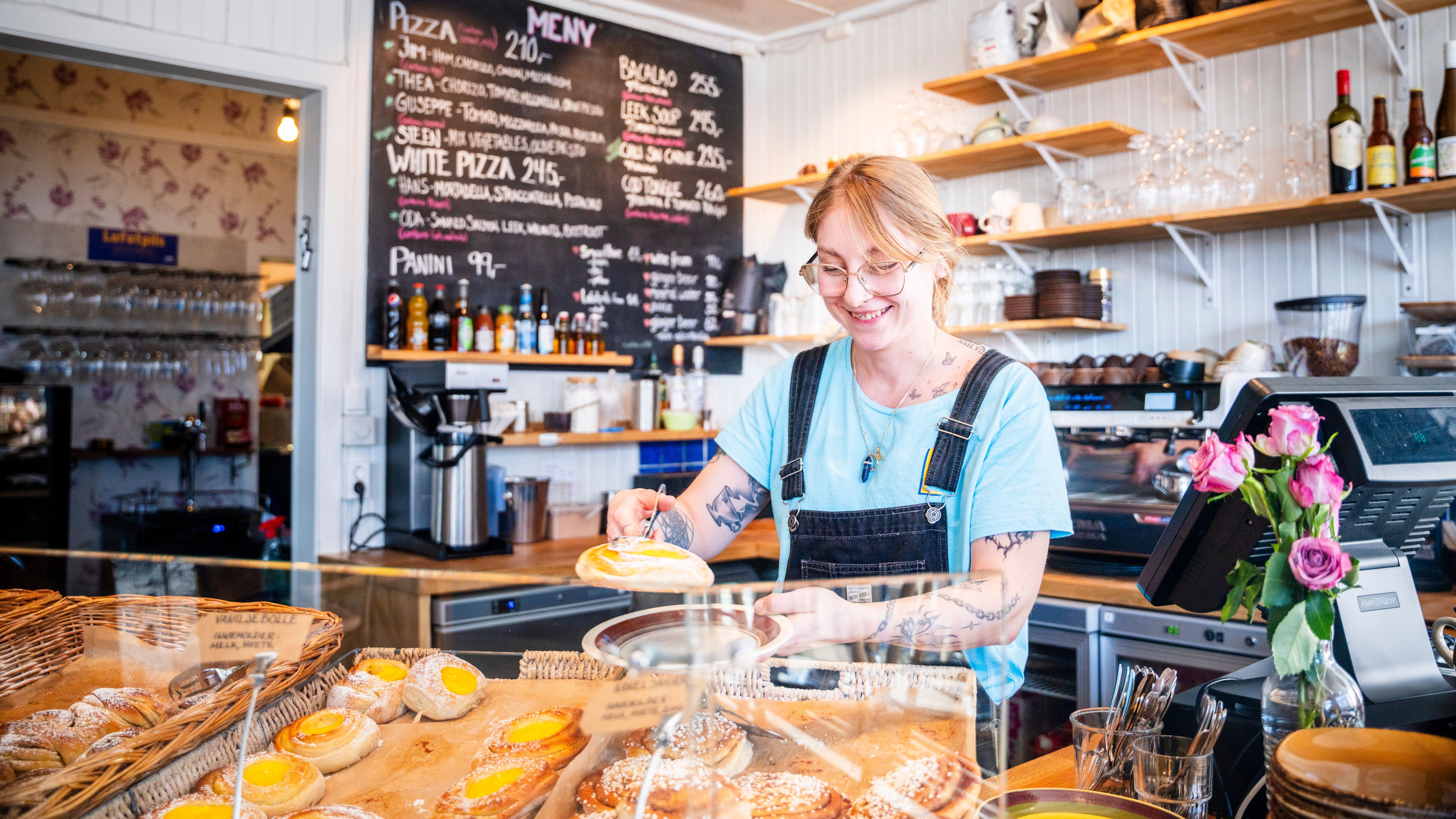 woman with cinnamon buns at Lysstøperiet cafe in Henningsvær