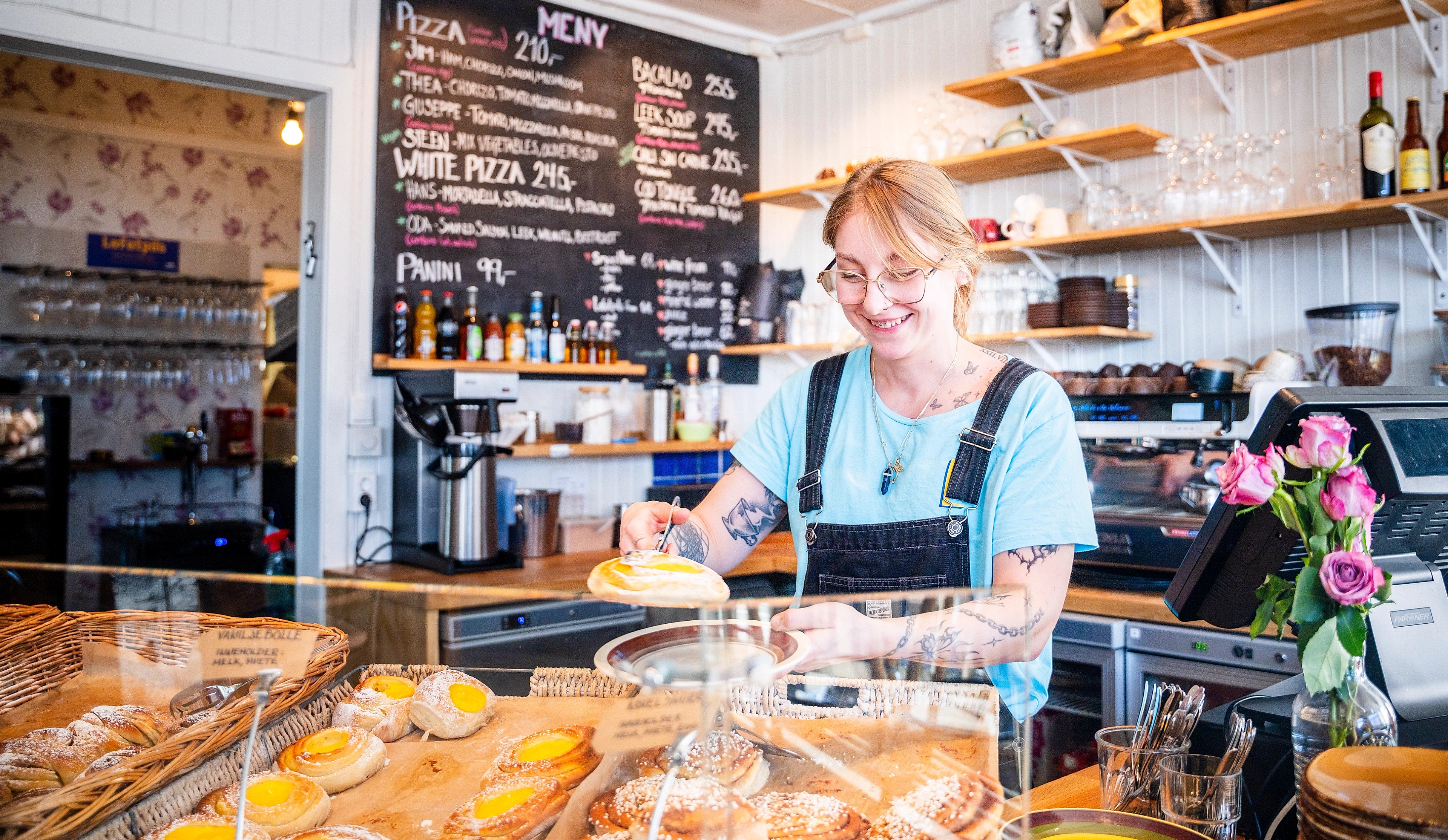 woman with cinnamon buns at Lysstøperiet cafe in Henningsvær