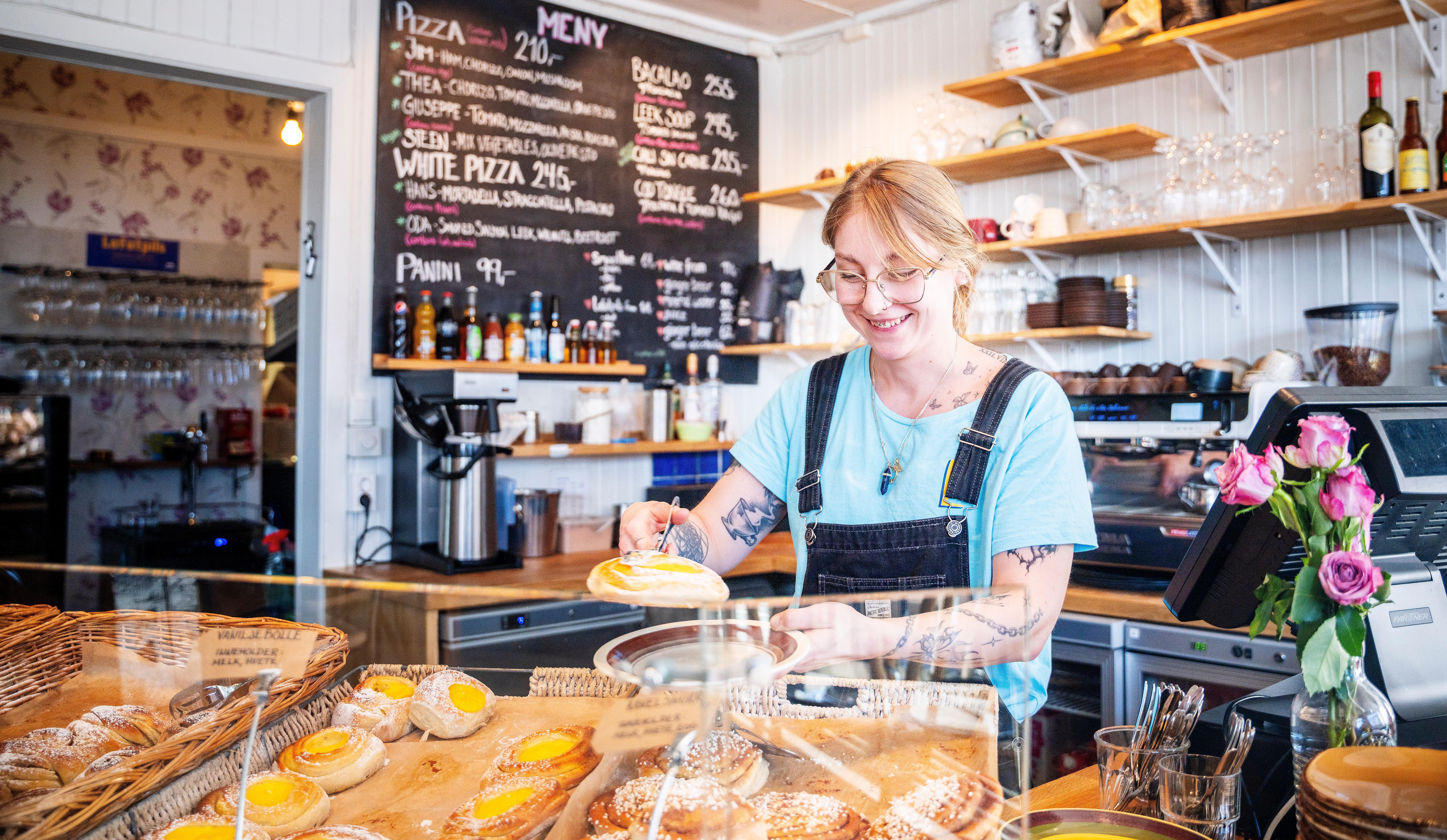 woman with cinnamon buns at Lysstøperiet cafe in Henningsvær