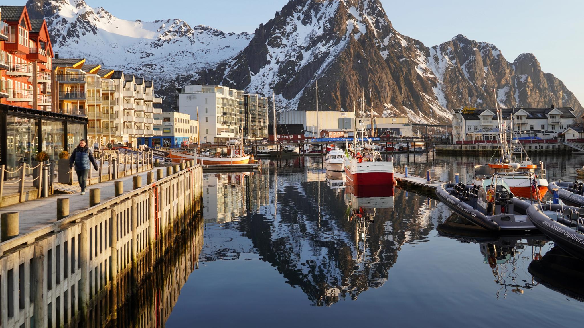 En hav i lavt sollys og høye fjell bak.