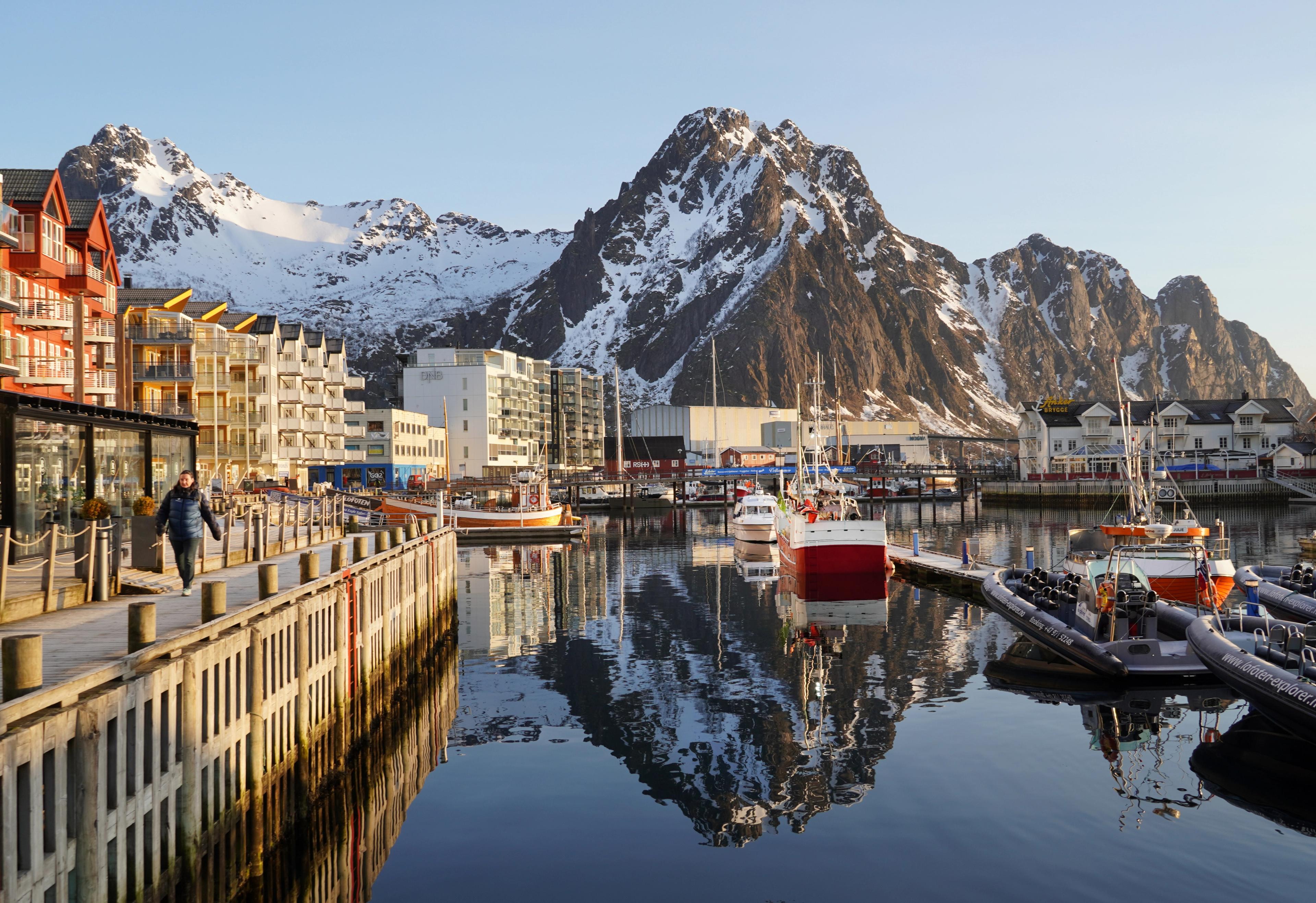 A harbour in low sunlight and high mountains behind