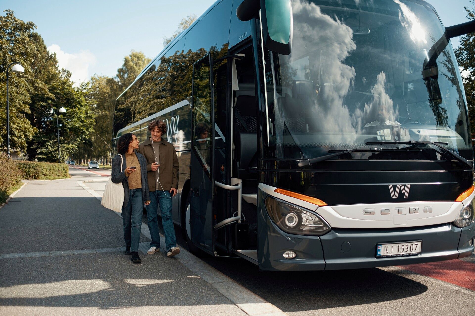 A woman and a man boarding a bus in Norway.
