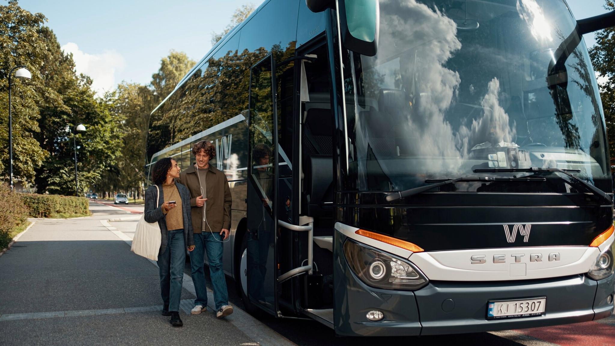 A woman and a man boarding a bus in Norway.