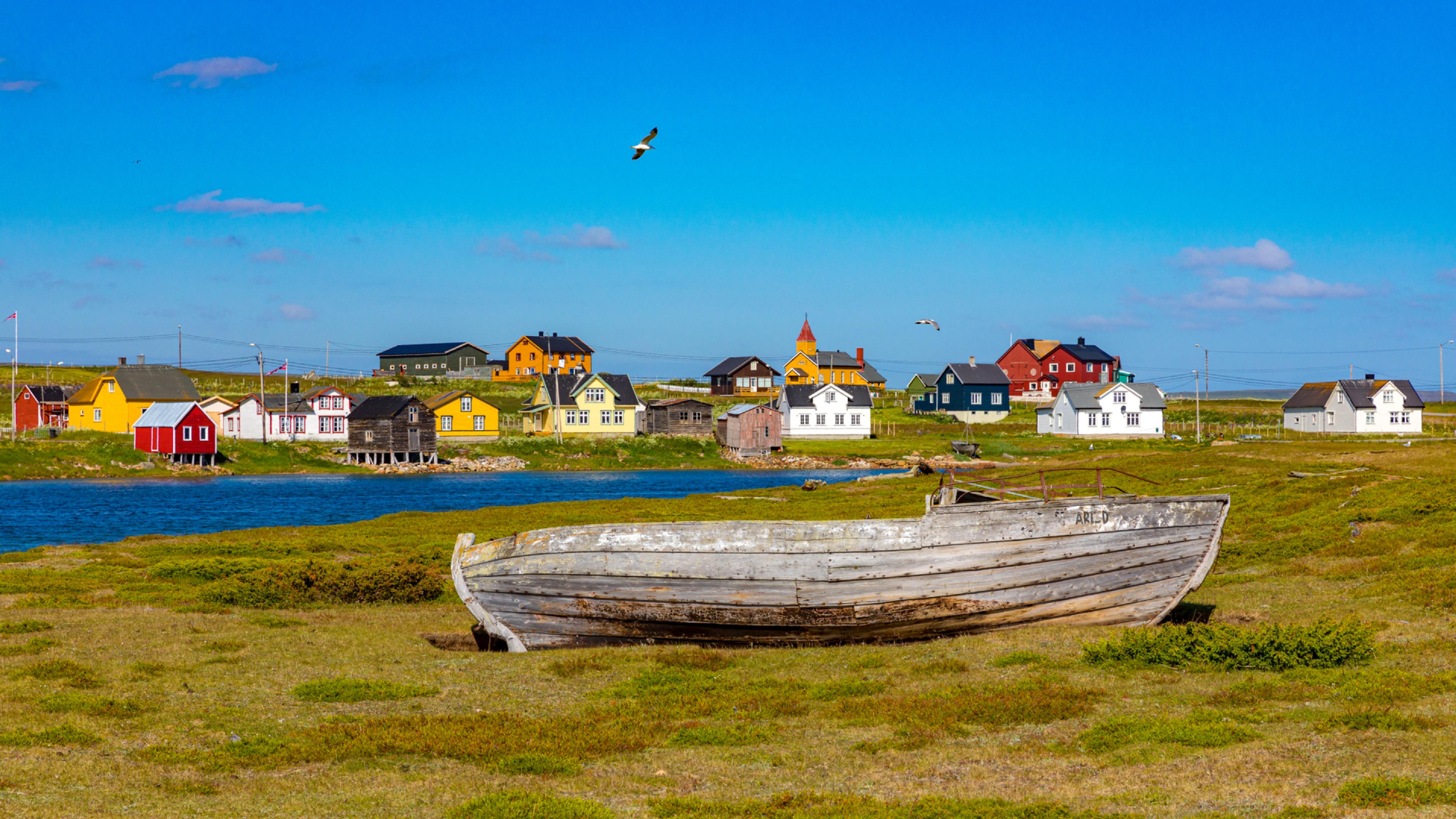 Boat laying on land in front of houses in Vadsø