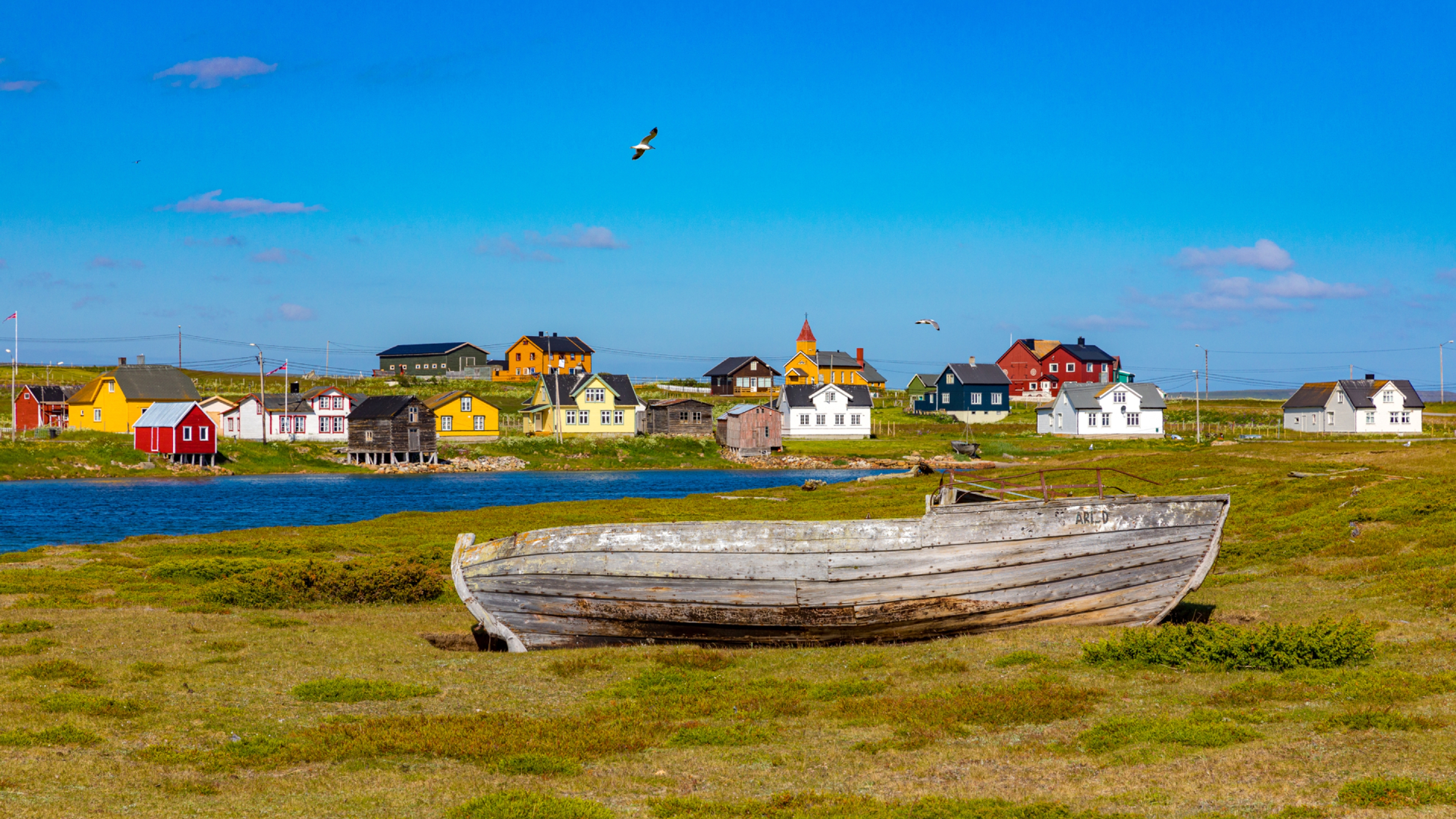 Boat laying on land in front of houses in Vadsø