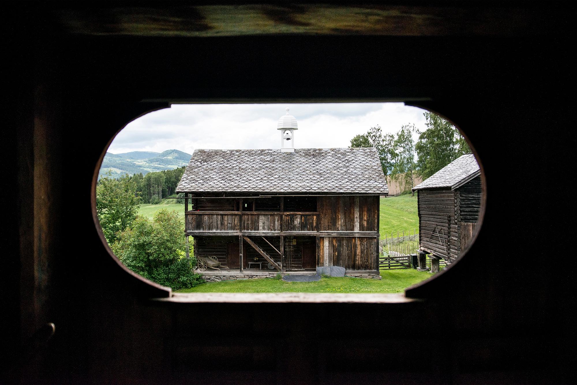 View on a wooden shed through a hole in the wooden wall at Sygard Grytting, Eastern Norway