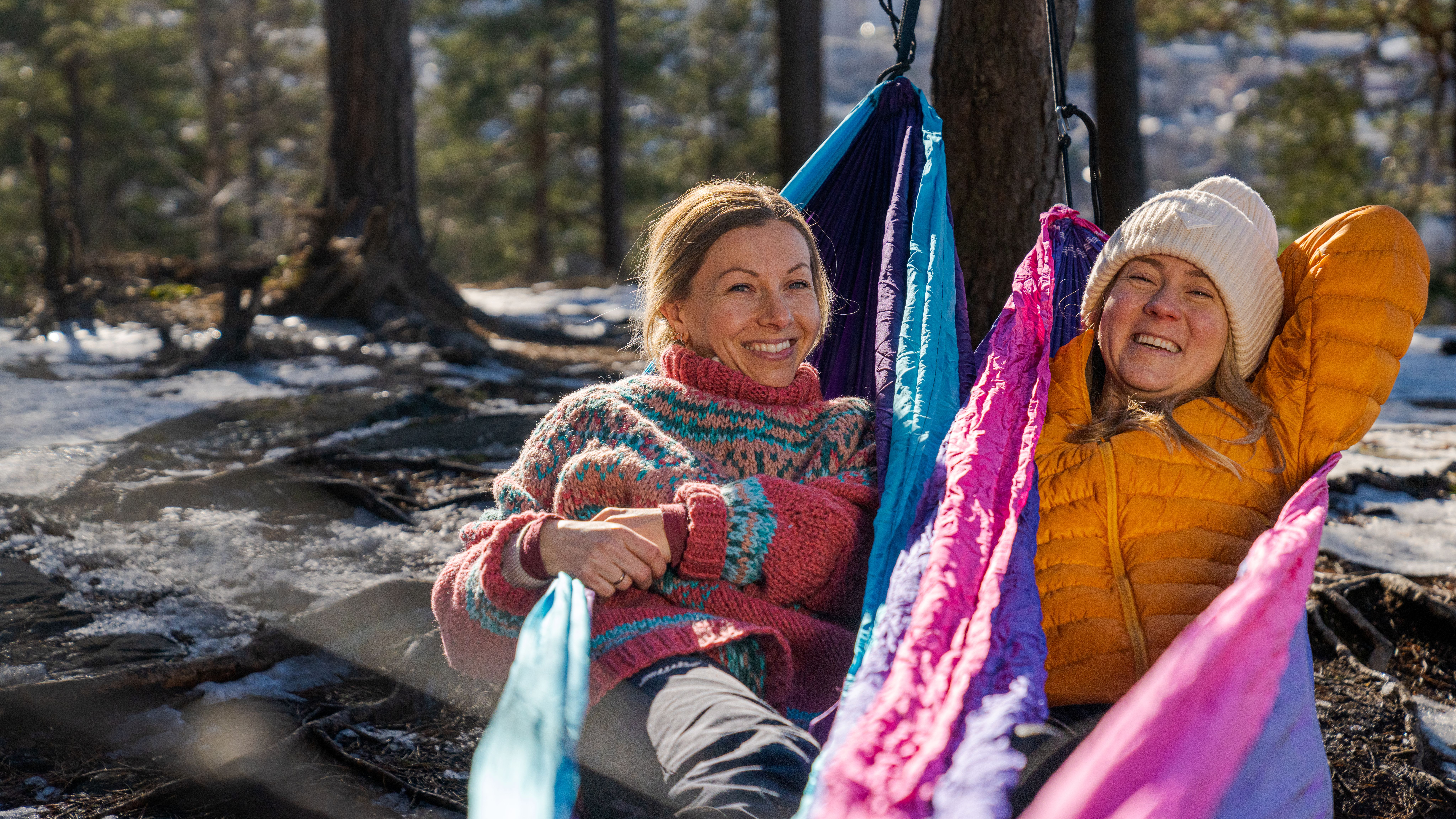 Women sit and watch the view of Oslo in knitted overalls