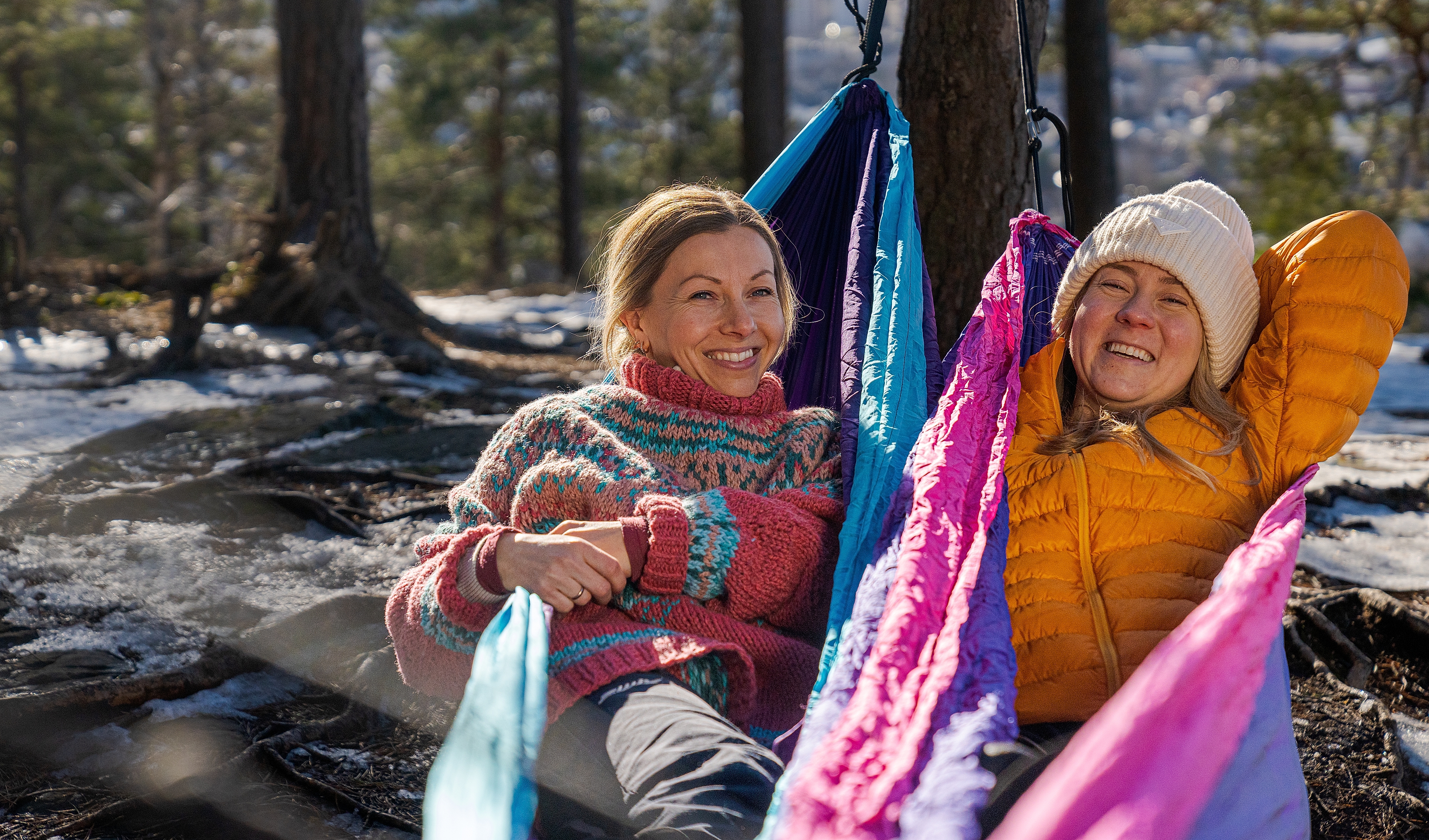 Women sit and watch the view of Oslo in knitted overalls