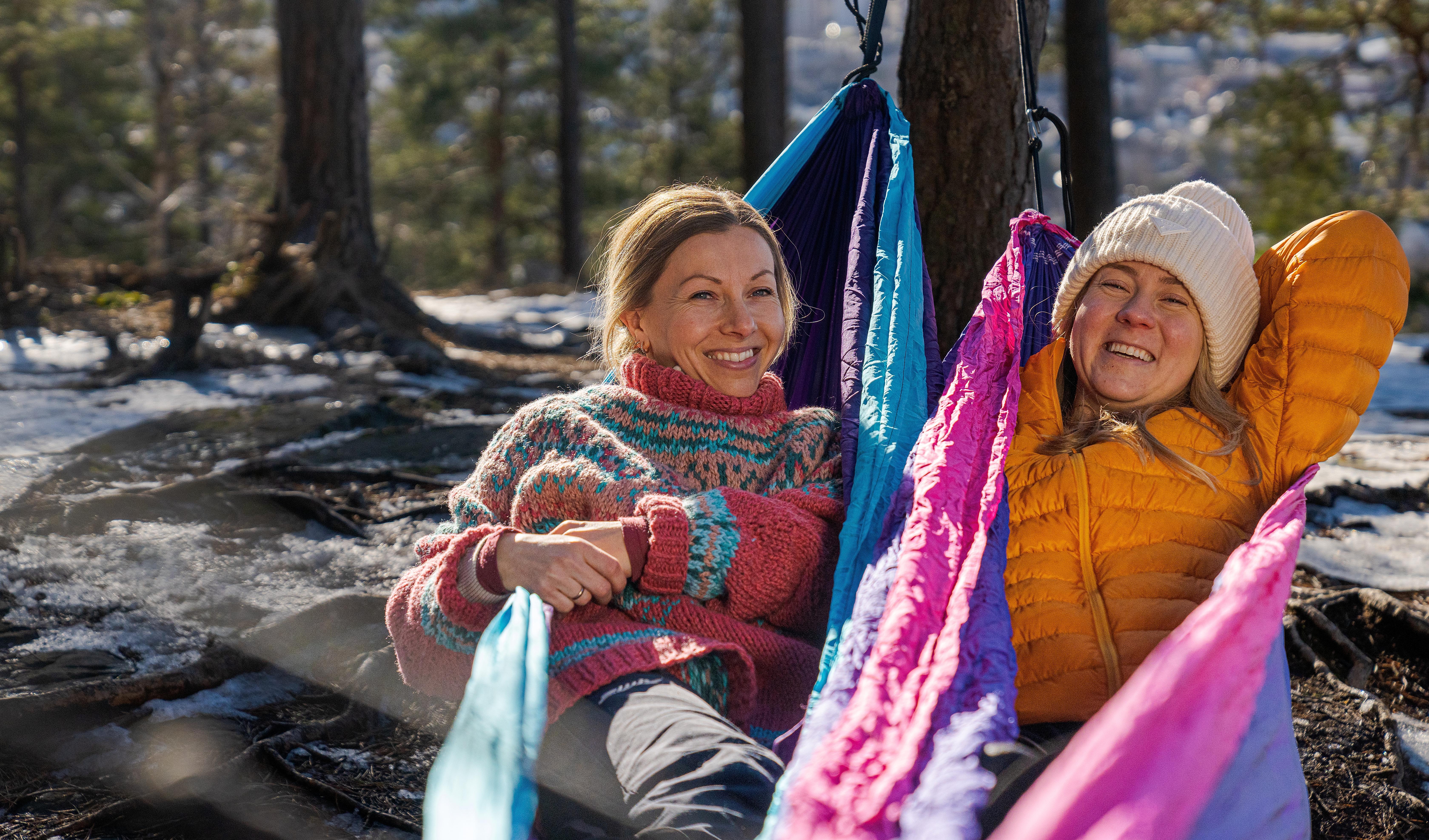 Women sit and watch the view of Oslo in knitted overalls