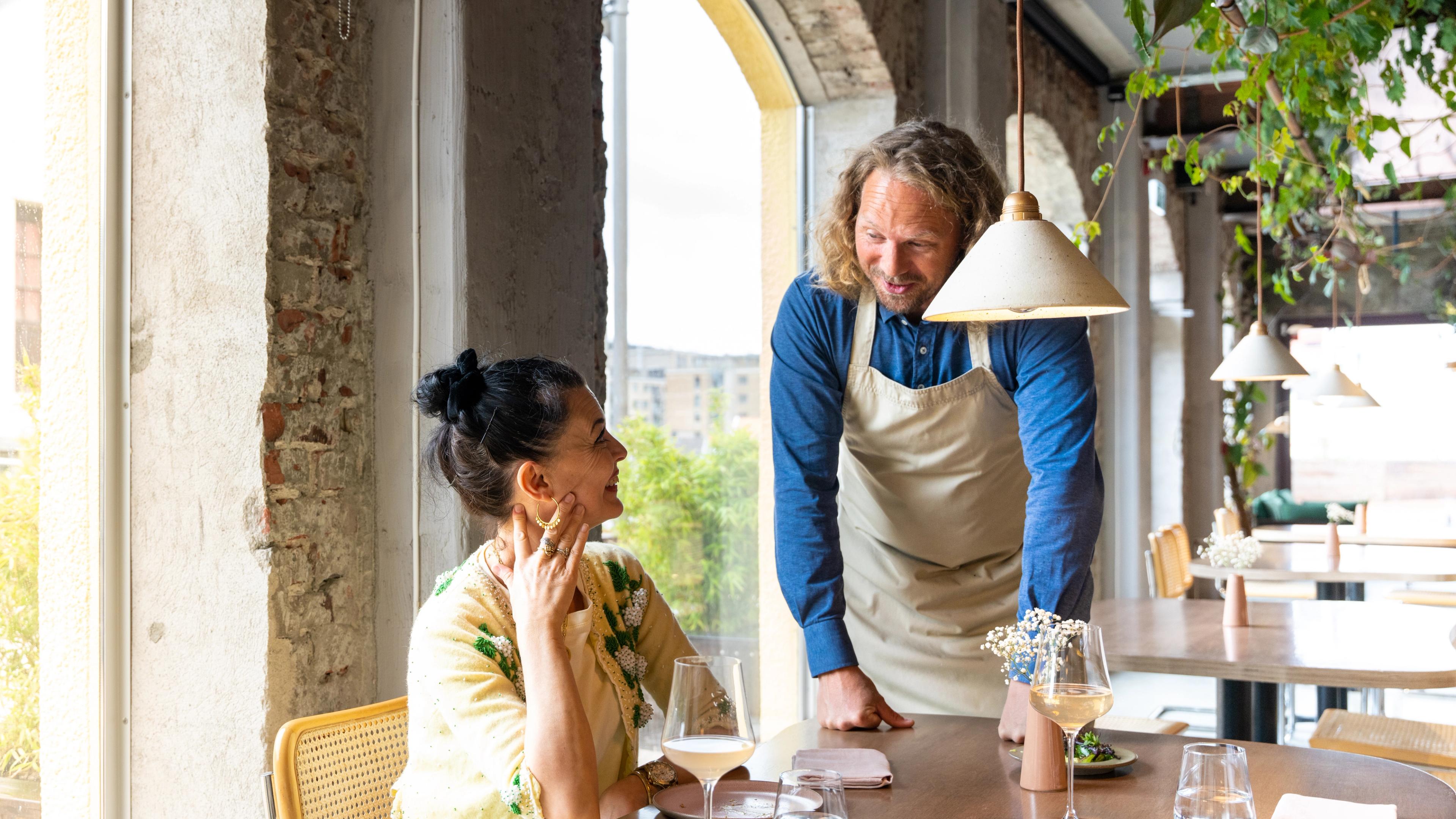The owner of the restaurant Bellies talks to a customar, in Stavanger, Fjord Norway