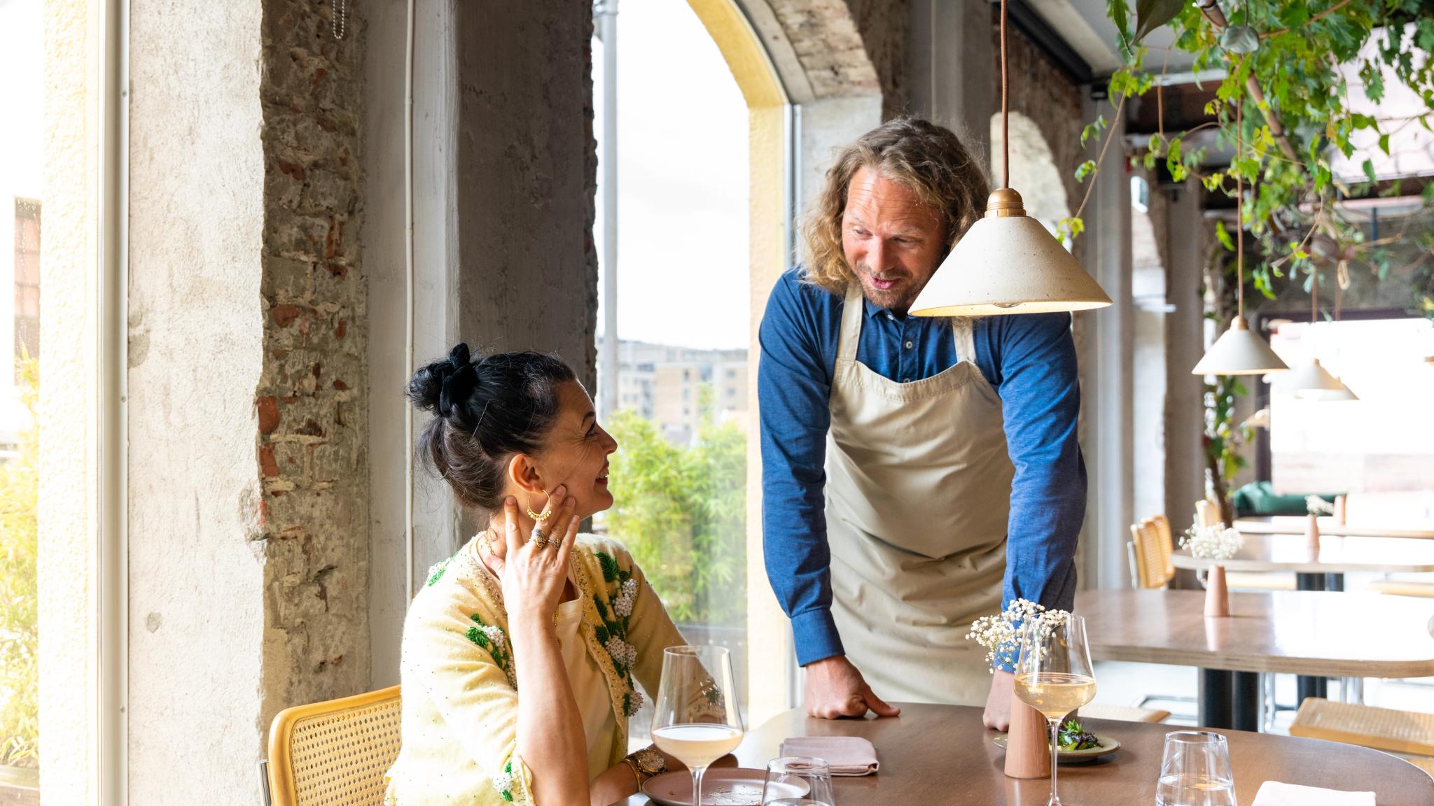 The owner of the restaurant Bellies talks to a customar, in Stavanger, Fjord Norway
