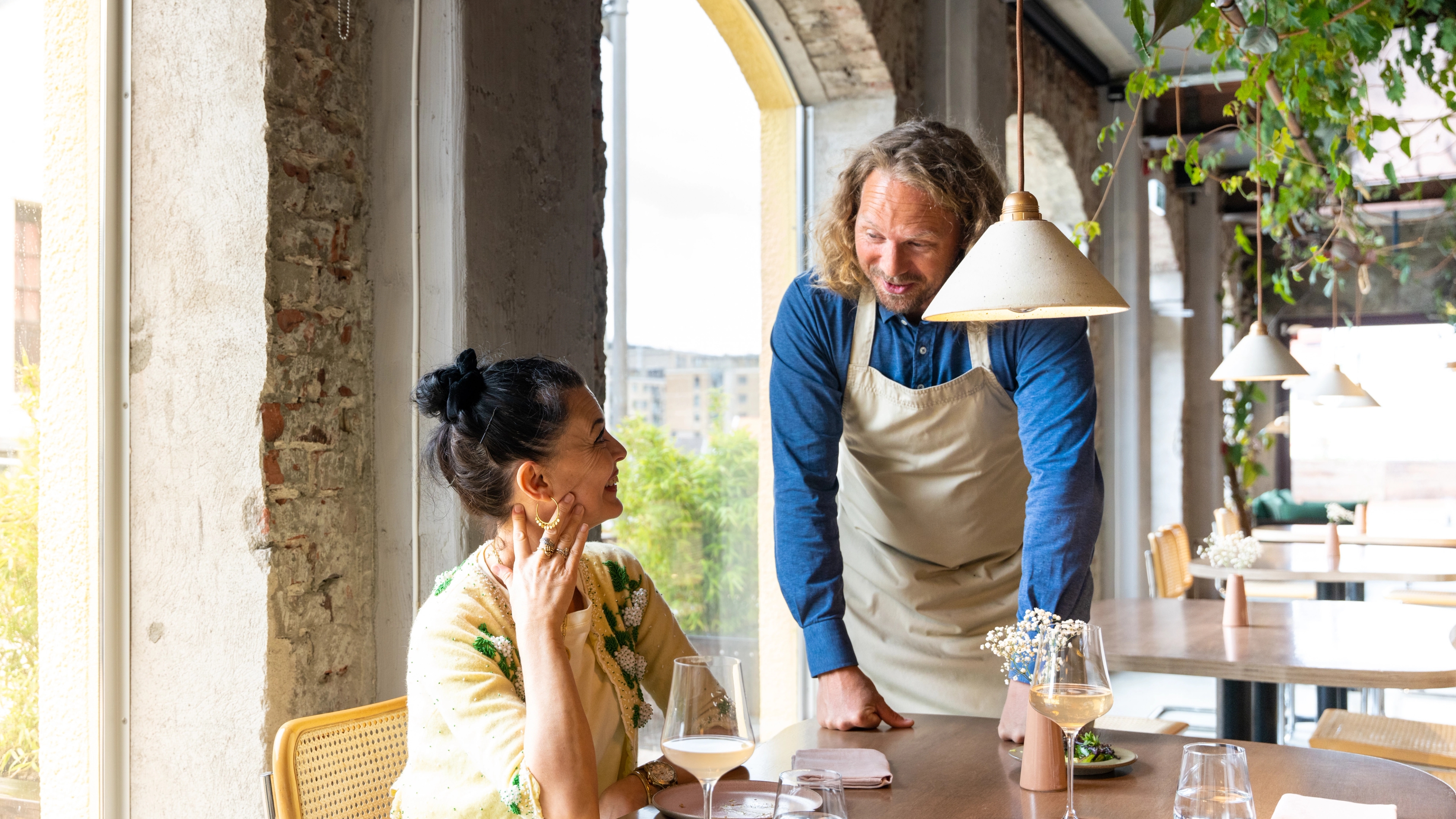 The owner of the restaurant Bellies talks to a customar, in Stavanger, Fjord Norway