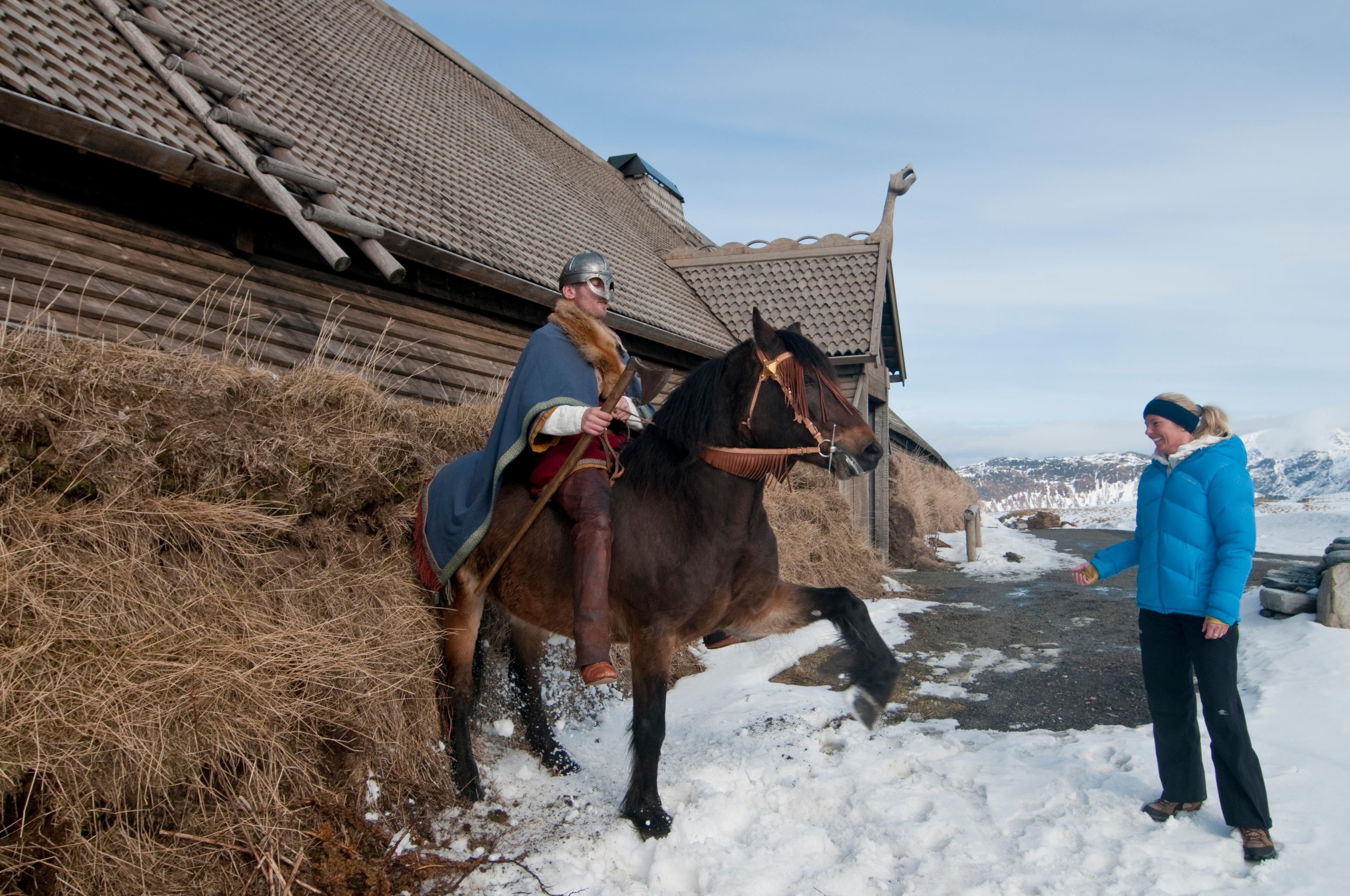 A Viking on his horse is posing for visitors at Lofotr Viking Museum in Lofoten, Northern Norway