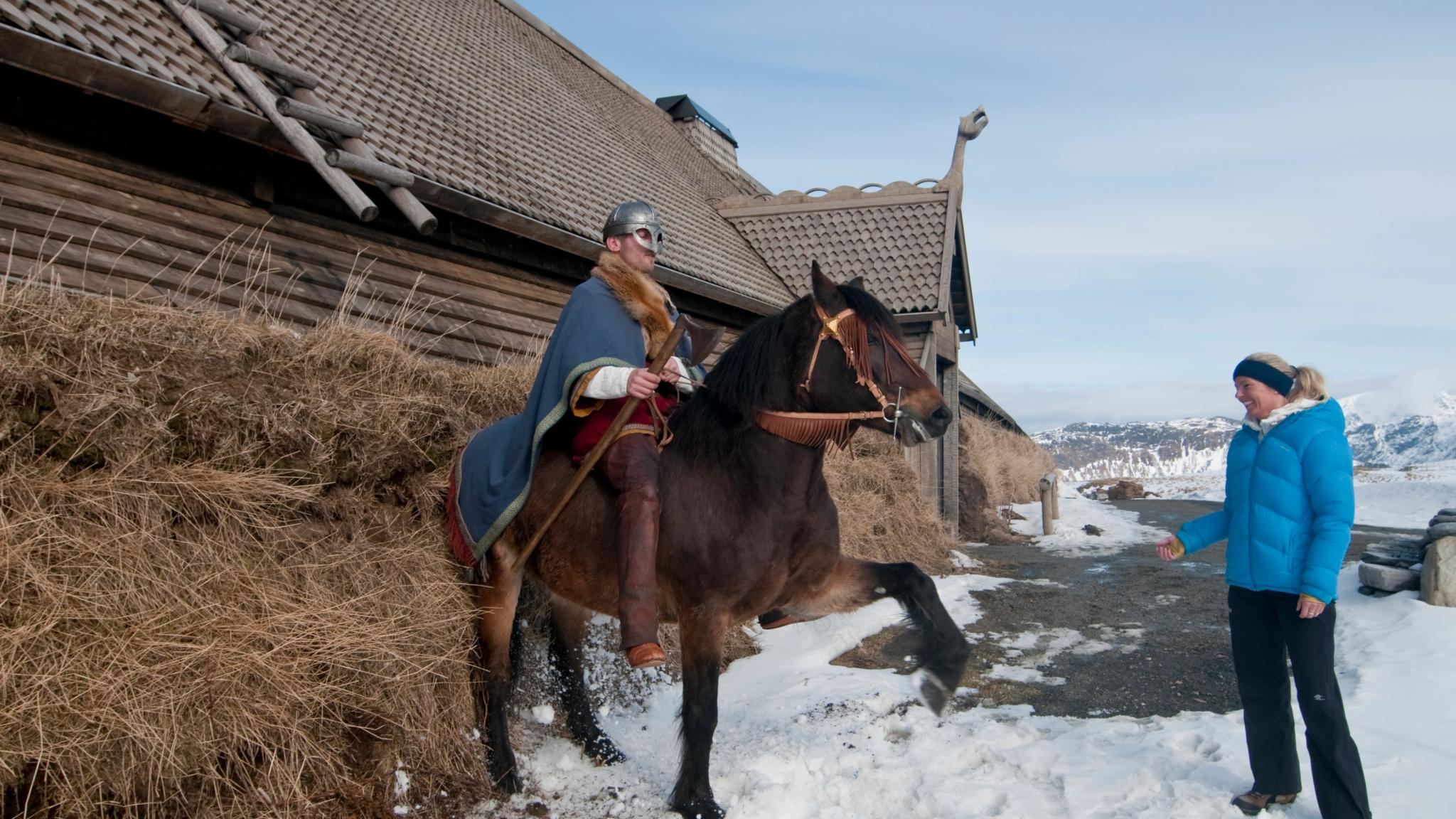 En viking til hest poserer for besøkende på Lofotr vikingmuseum i Nord-Norge