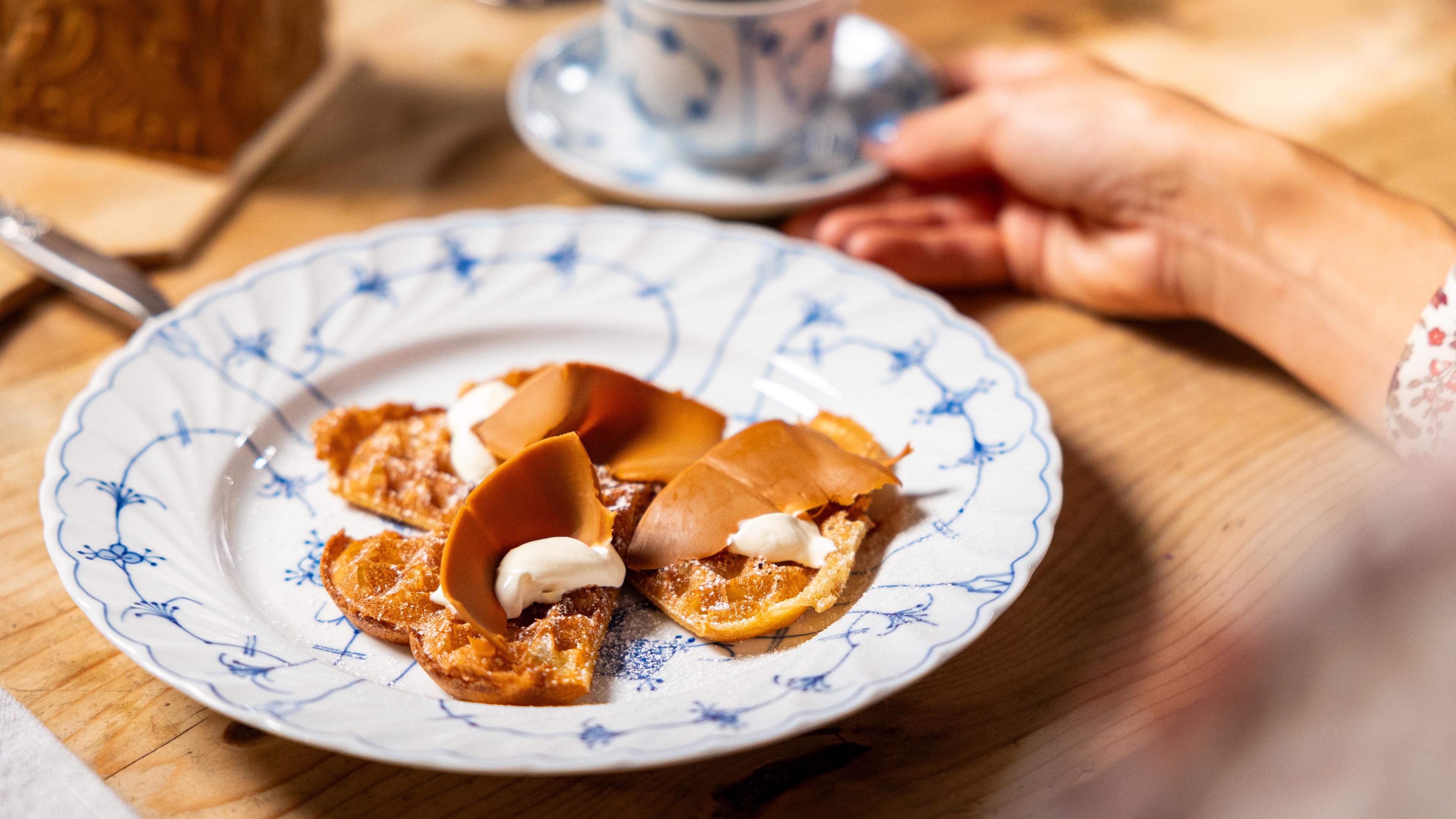A Norwegian waffle with brown cheese on a plate.