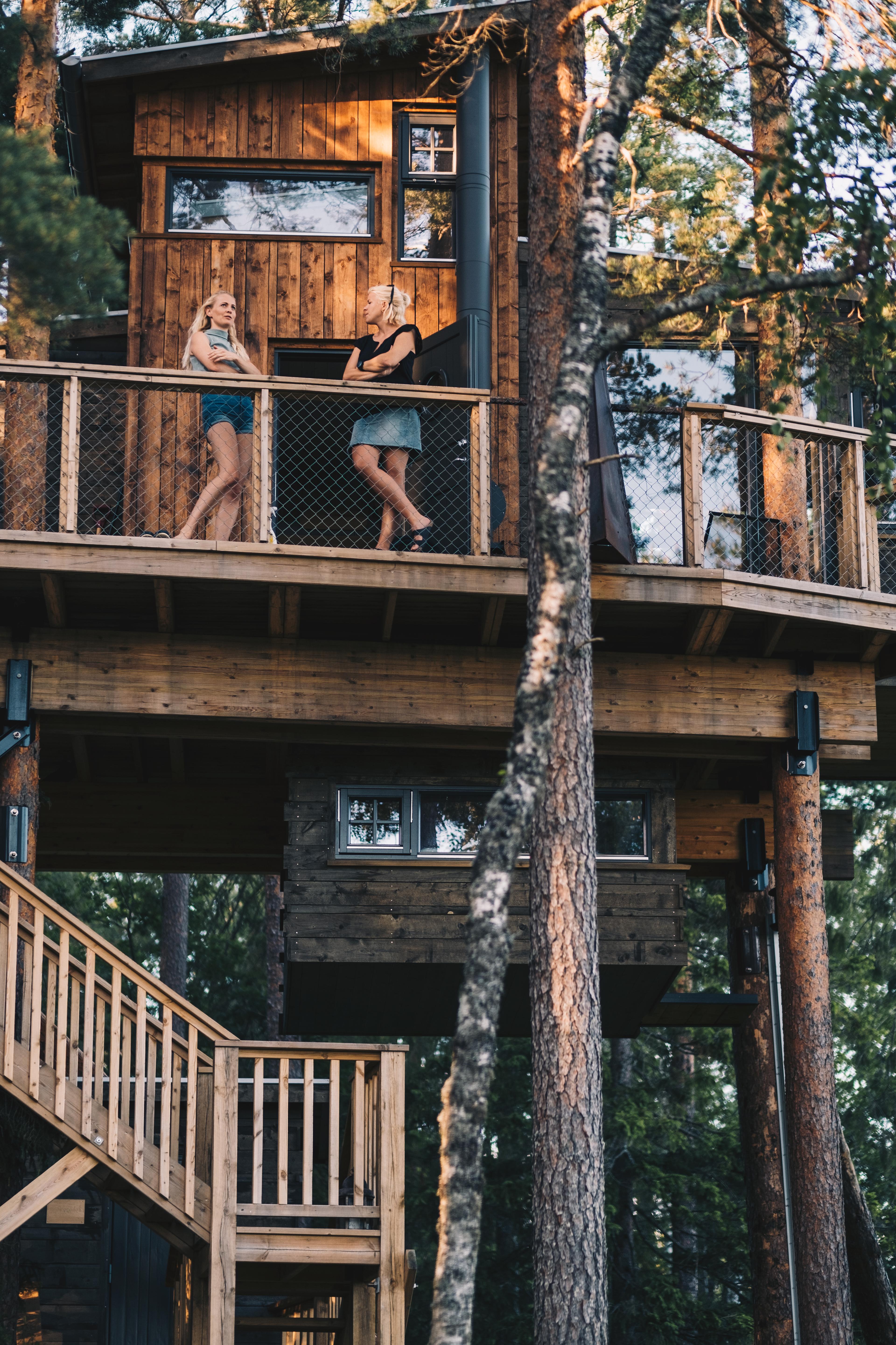 Two women standing on the terrace of Gjøkeredet tree house in Gjerstad, Southern Norway.
