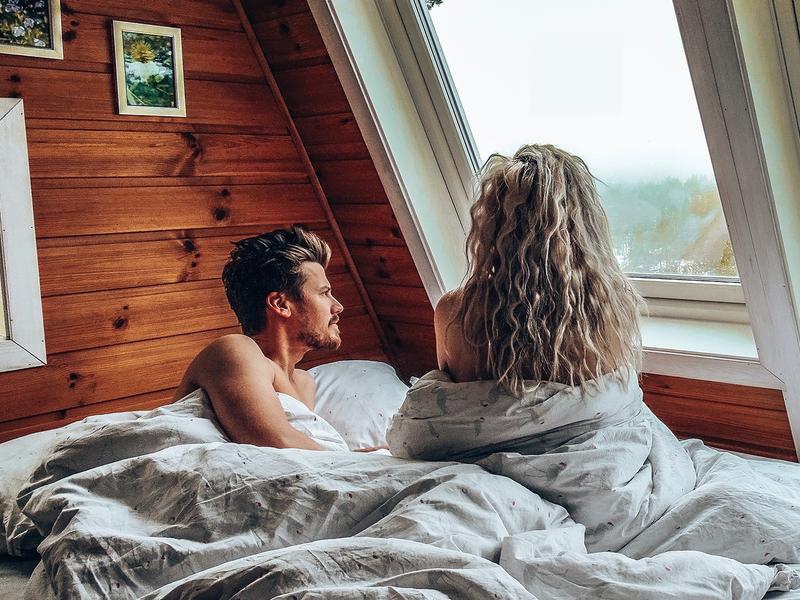 A man and a woman in bed inside on of the Micro cabins in Kragerø in Telemark, Eastern Norway