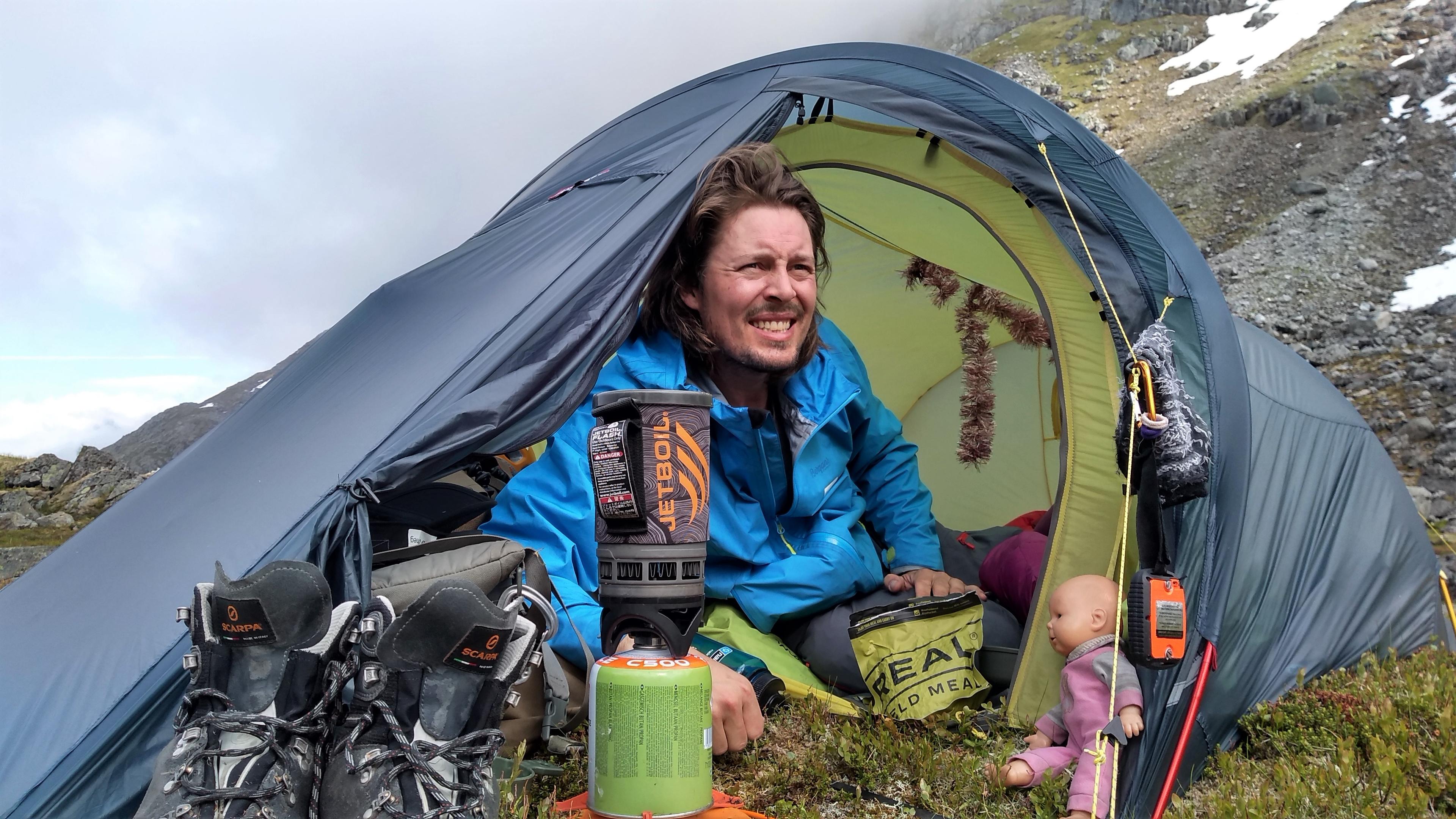 Alexander relaxing inside a tent by the Litlekoppvatnet lake in Hjørundfjorden, Fjord Norway