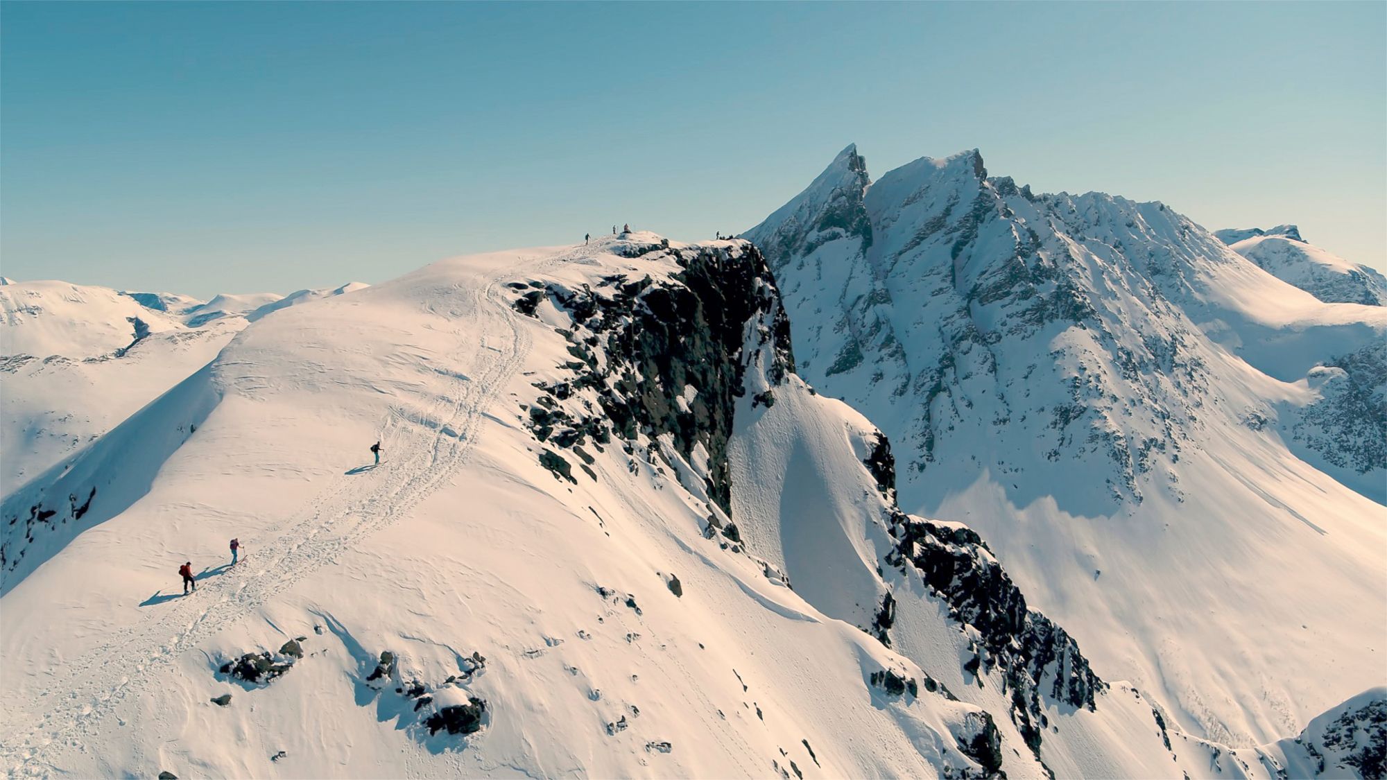 A group of people ski touring to a peak in Rauma, in the Northwest