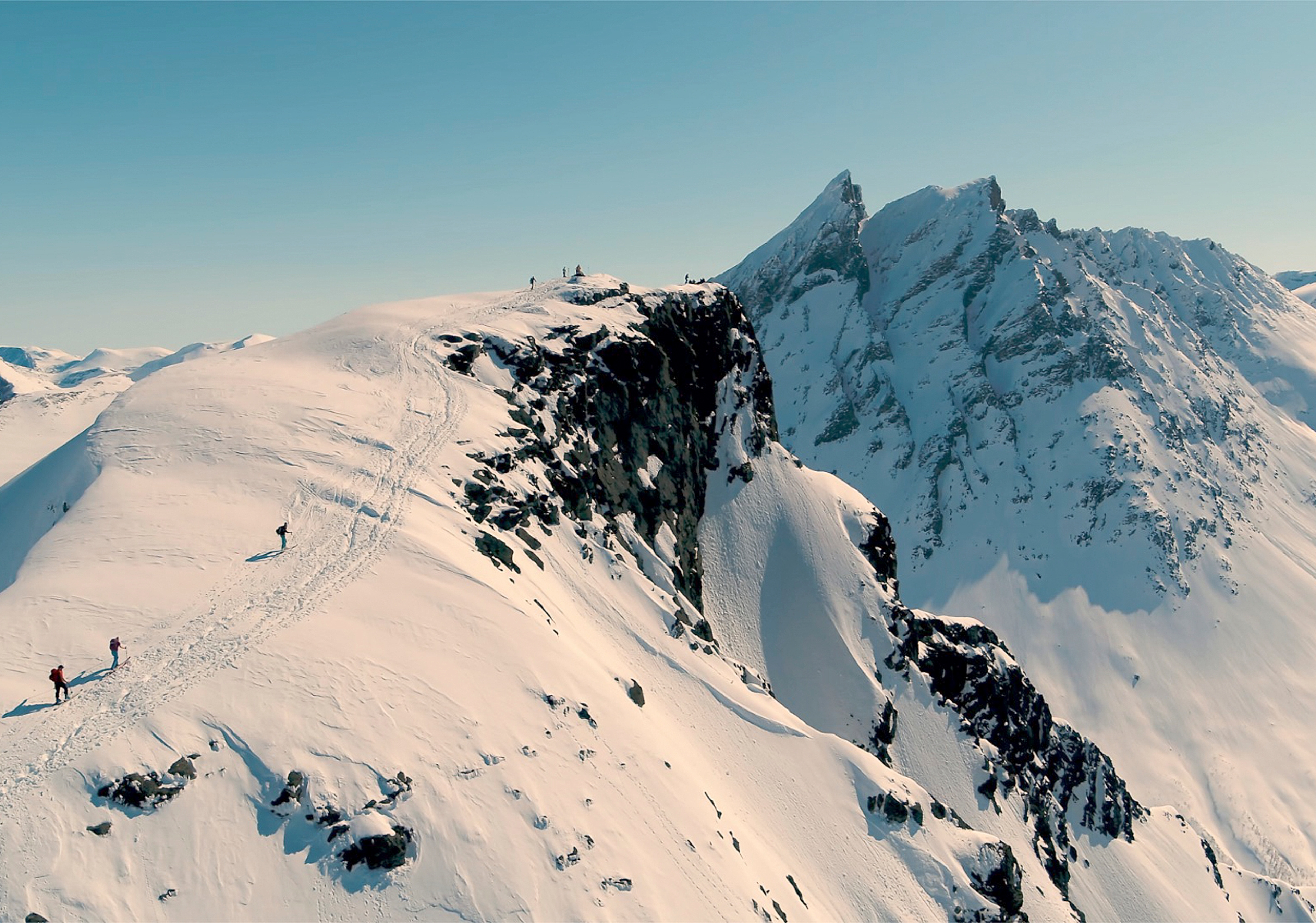 A group of people ski touring to a peak in Rauma, in the Northwest