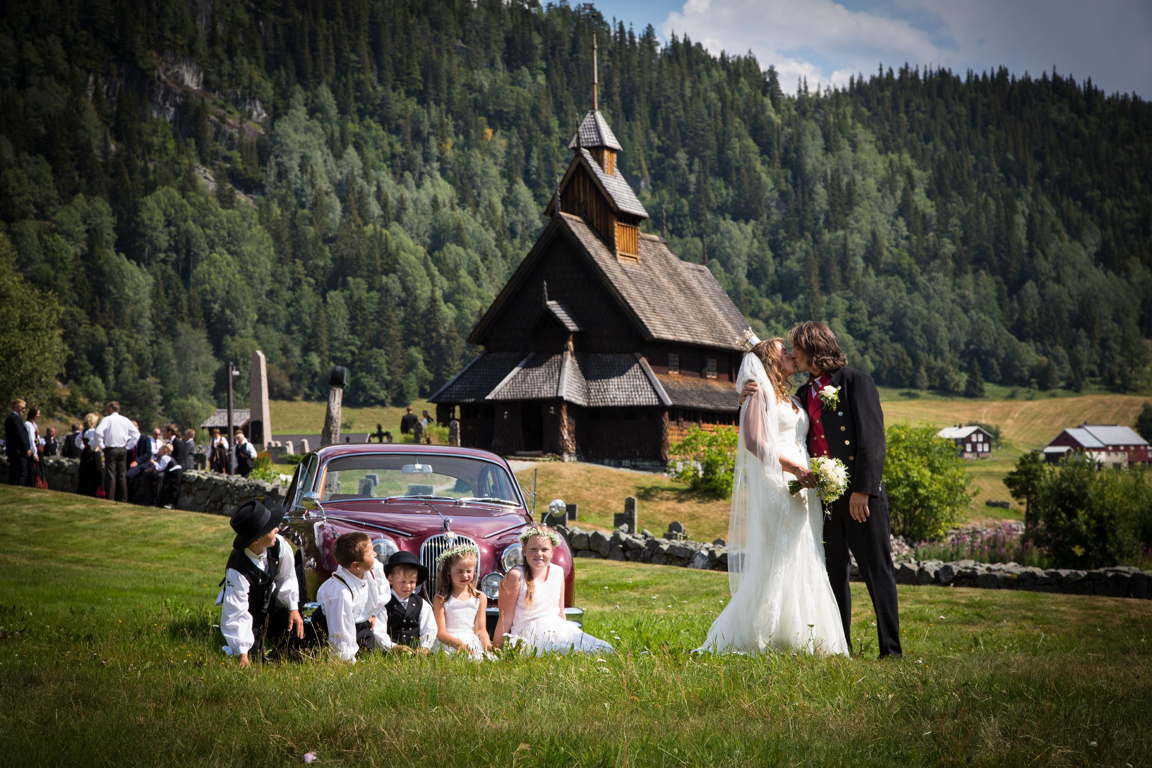 A wedding couple kisses in front of Eidsborg stave church in Telemark in Eastern Norway