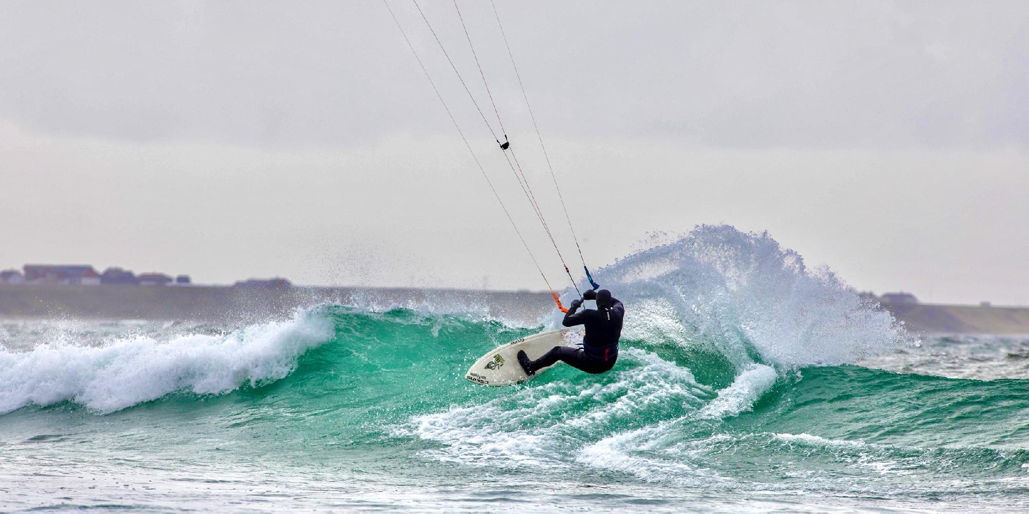 A person kiting on a wave in Fjord Norway.
