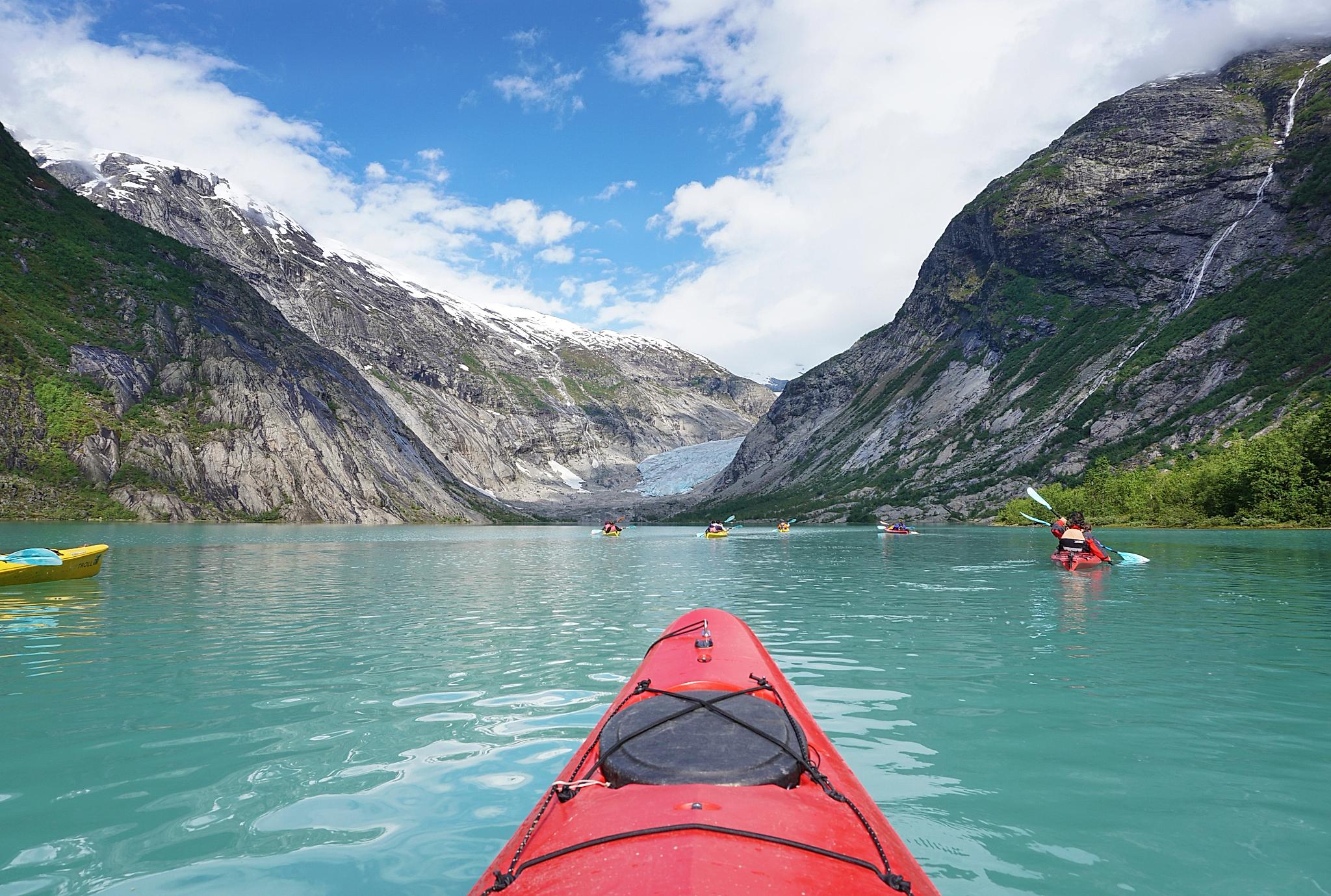 Spetsen på en kajak framför glaciären i Jostedalen, Fjord Norge