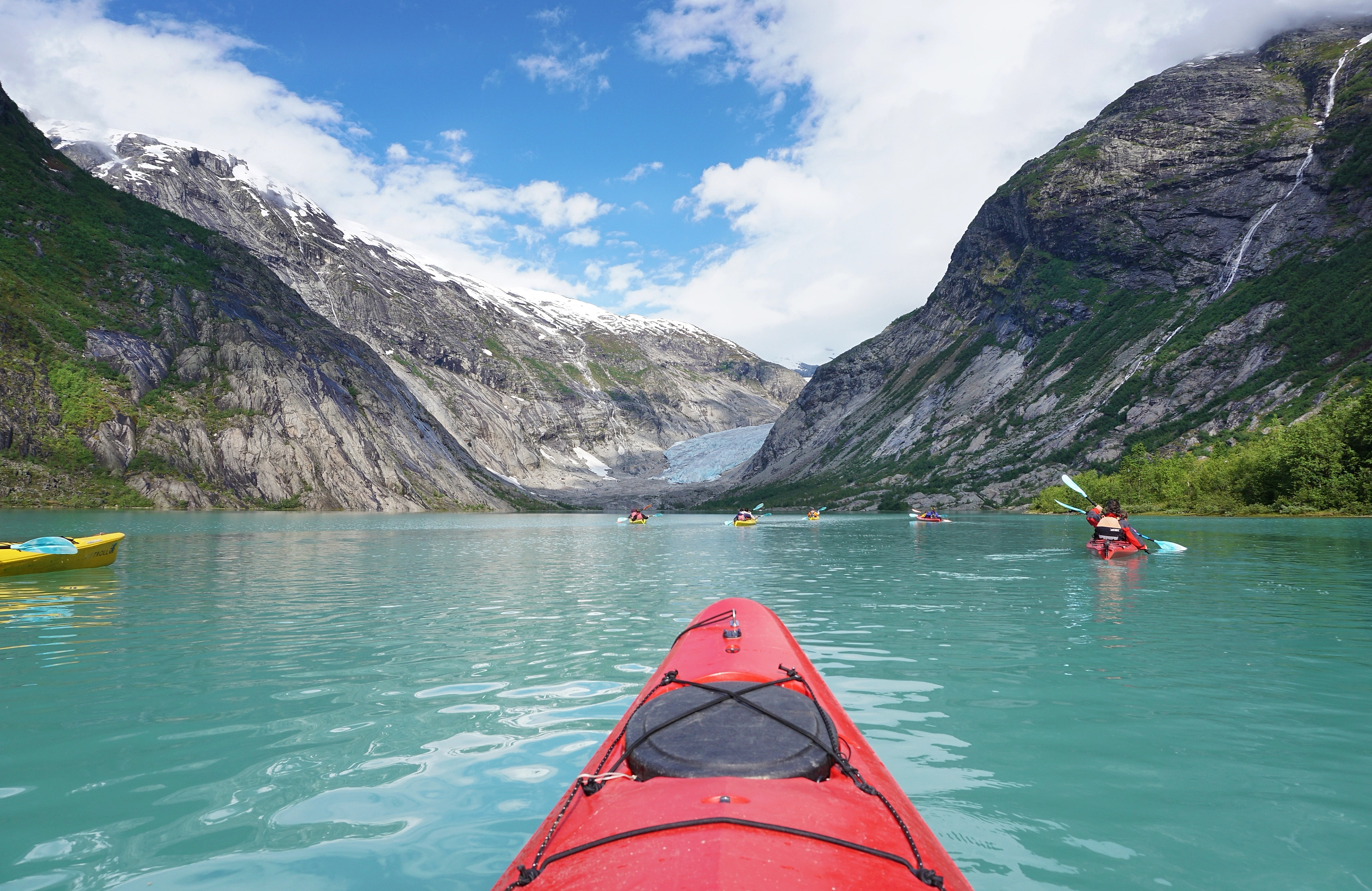 The tip of a kayak in front of glacier in Jostedalen, Fjord Norway