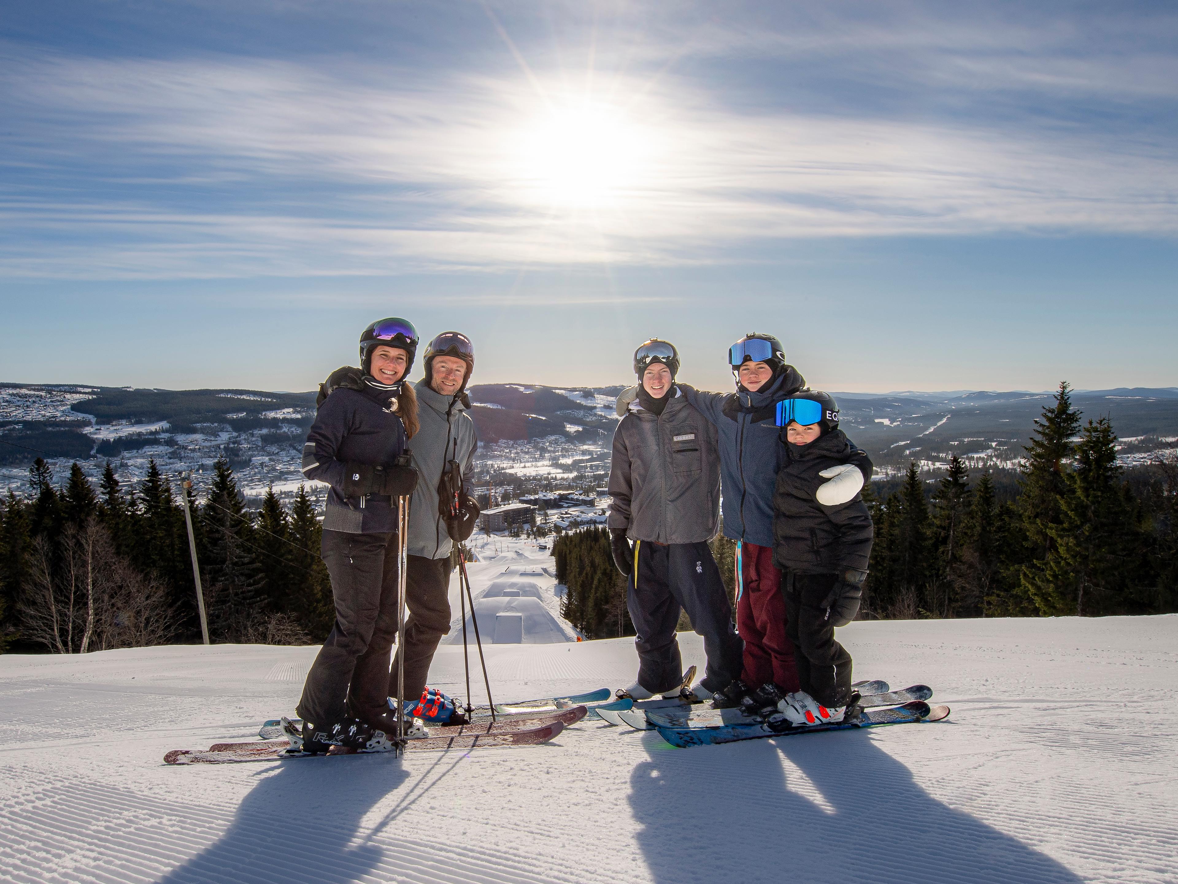 Mum, dad, and three sons on downhill skiis.