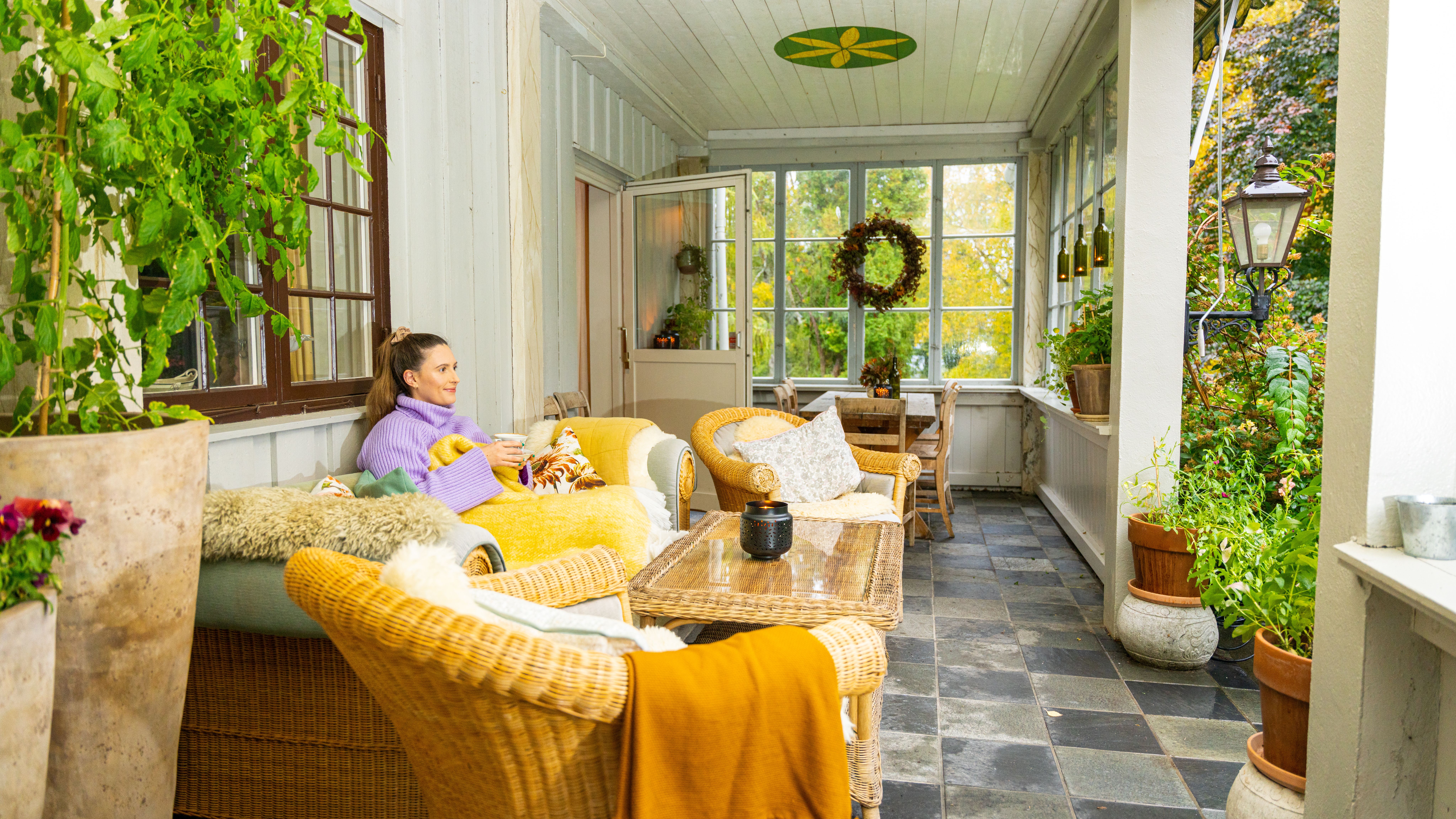 A girl enjoying a cozy farm holiday, relaxing at the porch with a cup of tea in Biri, Eastern Norway