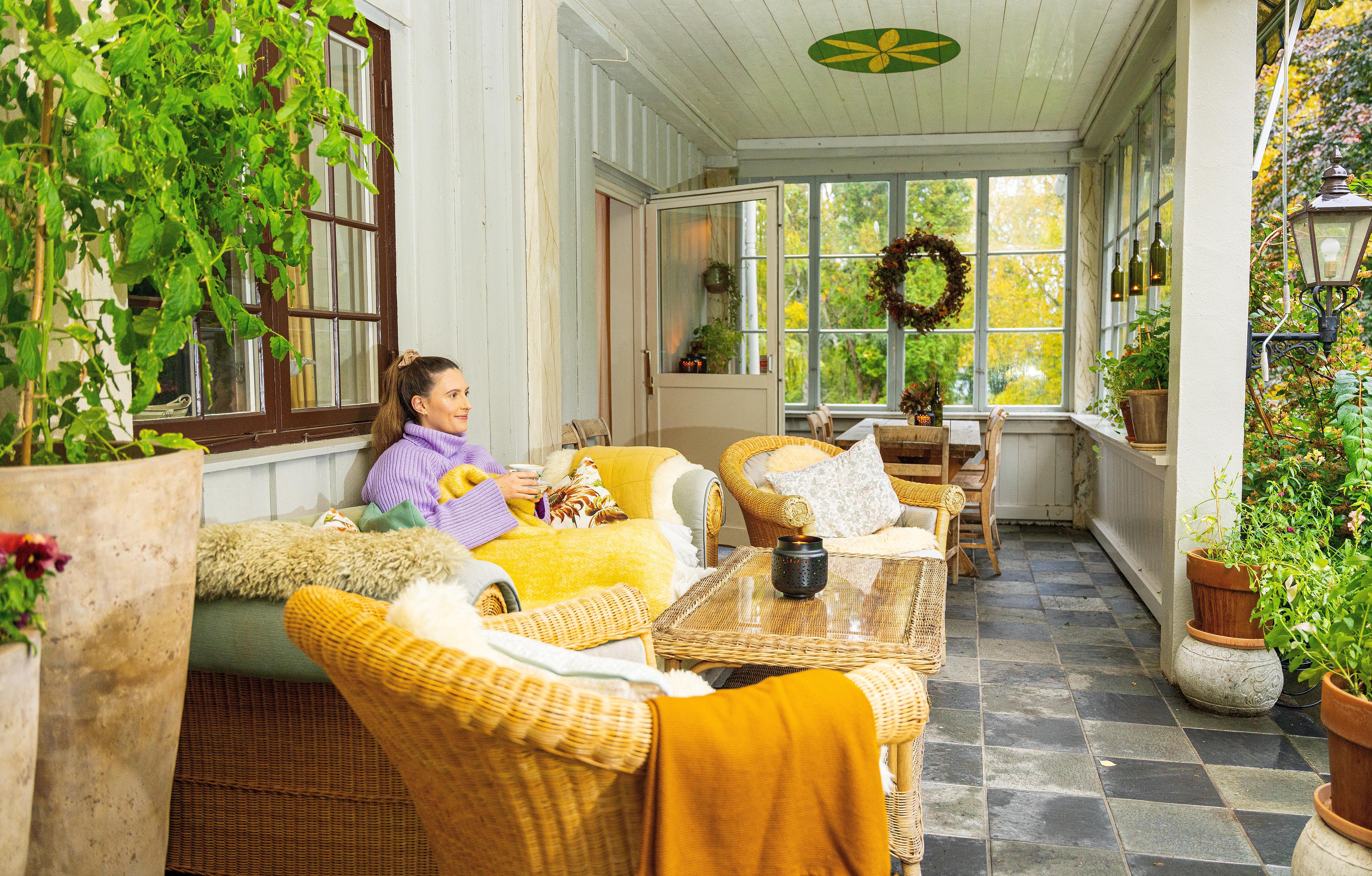A girl enjoying a cozy farm holiday, relaxing at the porch with a cup of tea in Biri, Eastern Norway